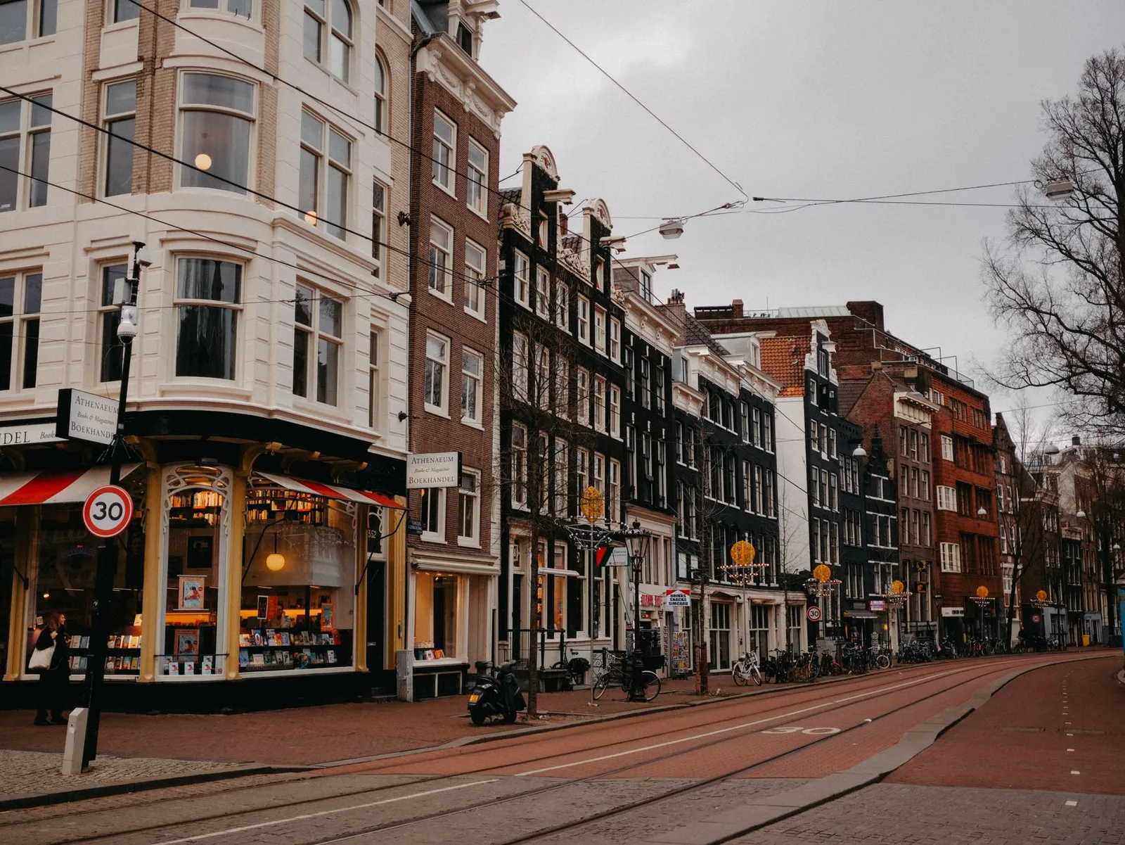 A picturesque street in Amsterdam featuring historic Dutch architecture and vibrant urban life.
