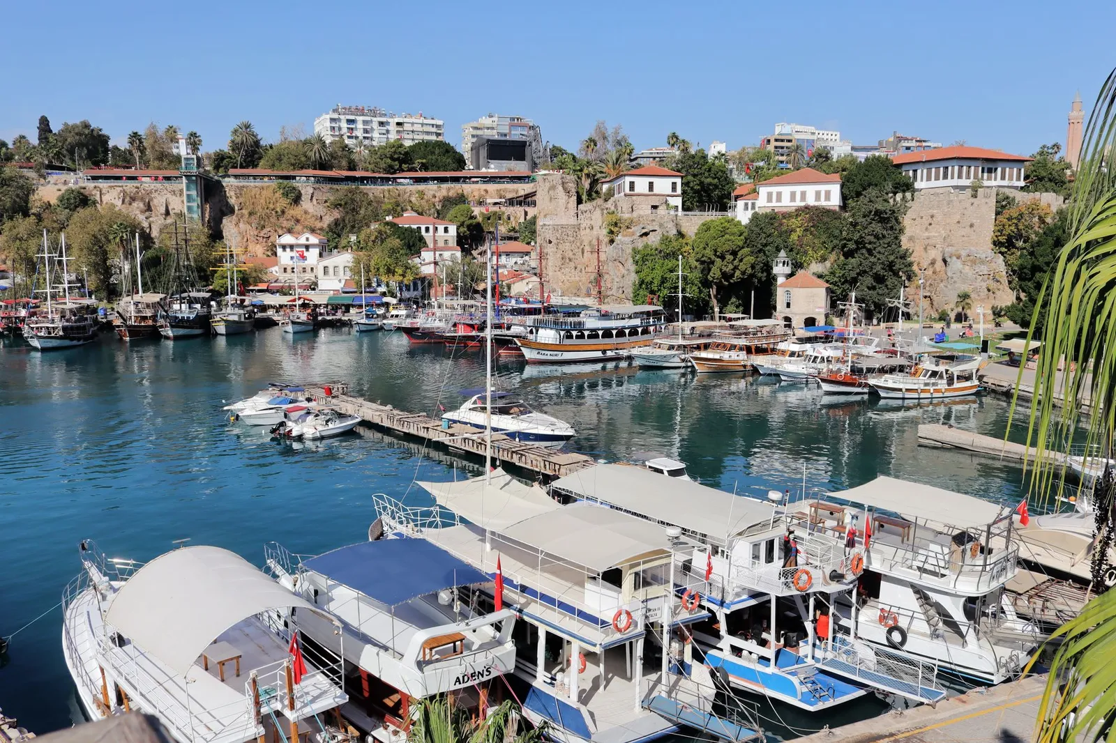 Explore the vibrant old town harbor in Antalya, Turkey, full of yachts and historic charm.