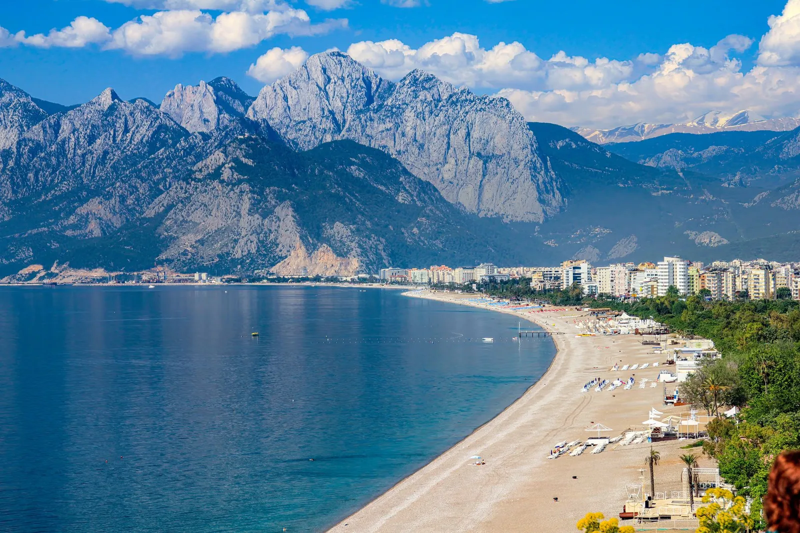 Stunning aerial view of Antalya beach with Taurus Mountains and cityscape in Türkiye.