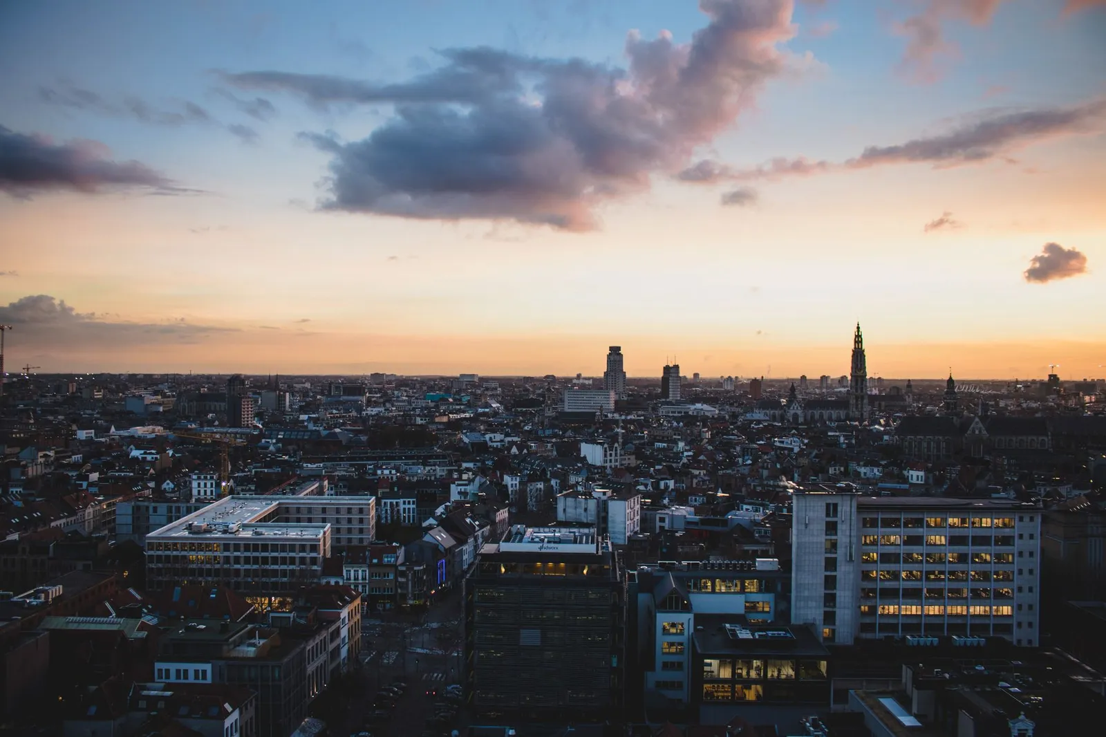 A stunning aerial view of Antwerp, Belgium, cityscape at dusk with vibrant sky colors.