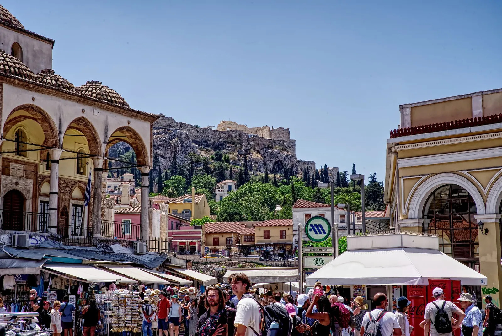 Bustling market in Athens near the Acropolis, featuring vibrant street life and historic architecture.