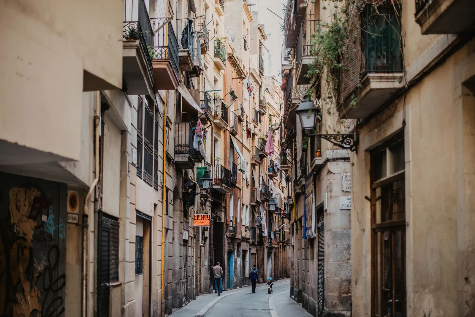 Explore the narrow, historic street in Barcelona's Gothic Quarter with vibrant architecture.