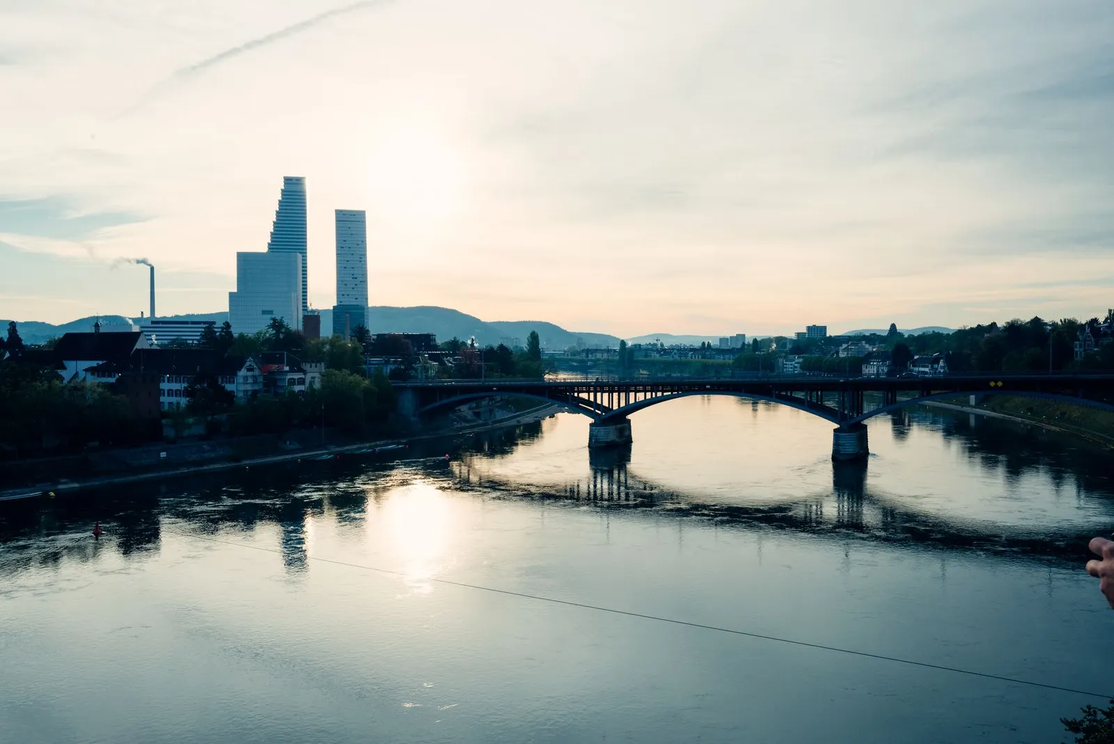 Captivating view of Basel's skyline and the Rhine River at sunset, showcasing modern architecture.