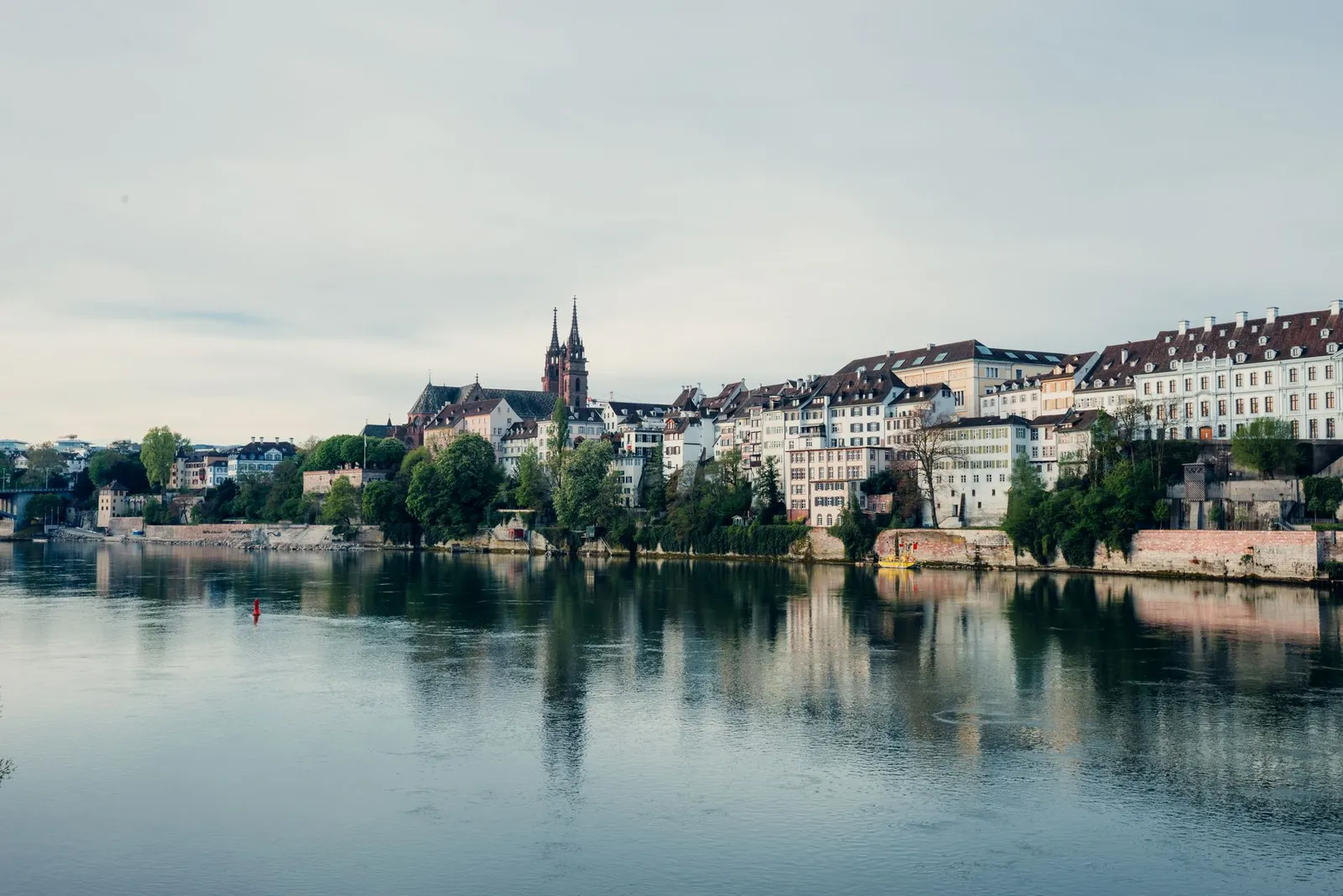 Charming riverfront view of Basel, Switzerland, showcasing historic architecture along the Rhine River.