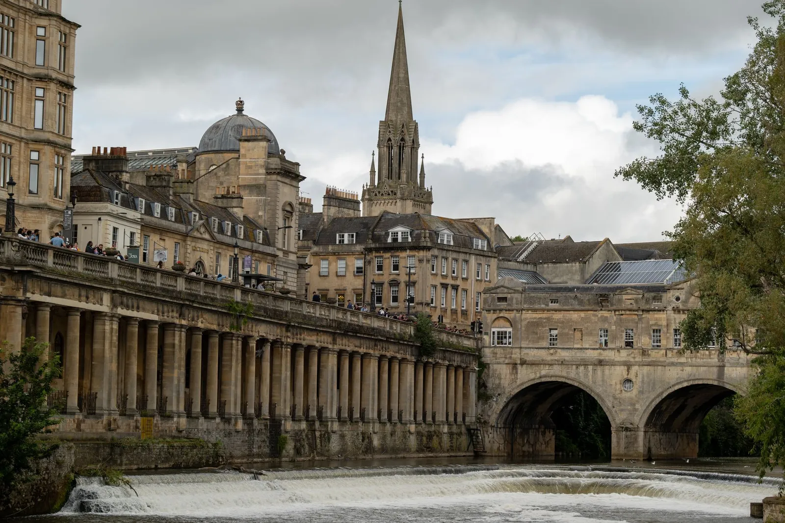Scenic view of Pulteney Bridge spanning the river in Bath, England with historic architecture.