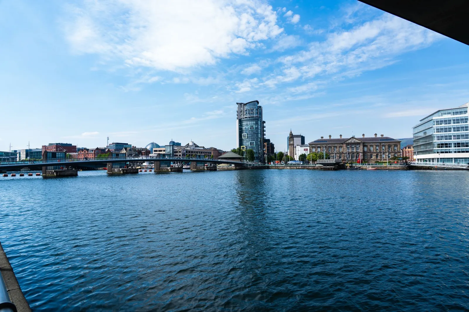 View of the Lagan River with the Belfast skyline, showcasing modern and historic architecture.
