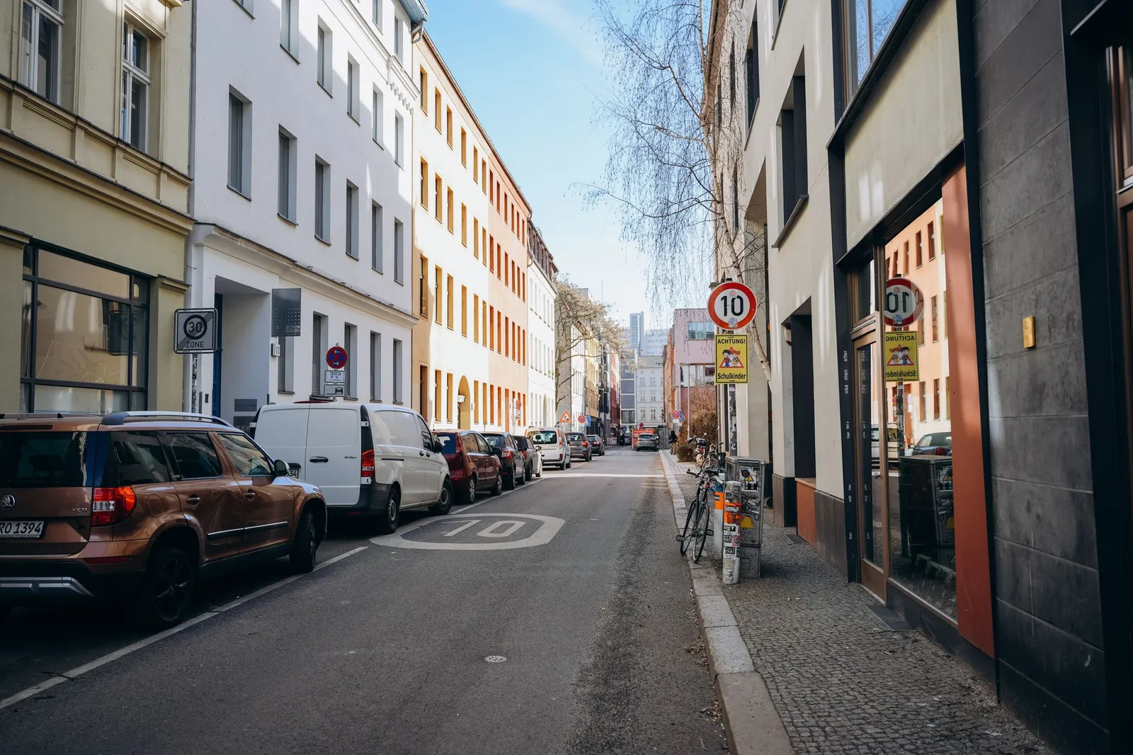 Daytime street view in Berlin showcasing urban architecture and parked cars.