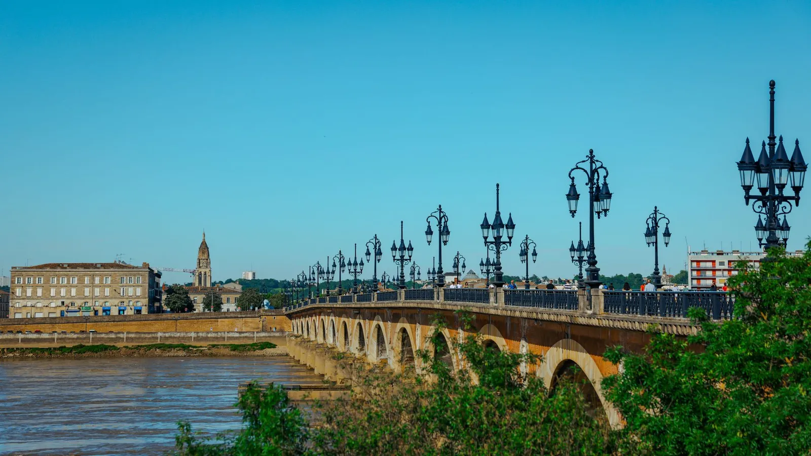 Elegant view of Pont de Pierre bridge in Bordeaux, France on a sunny day.