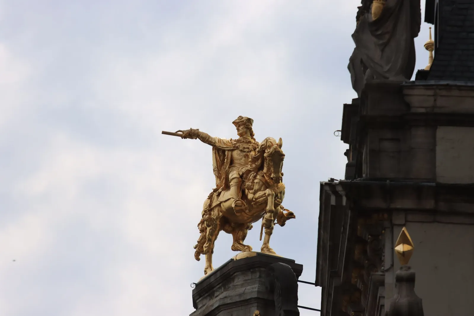 A detailed shot of a golden equestrian statue atop a building in Brussels, Belgium.