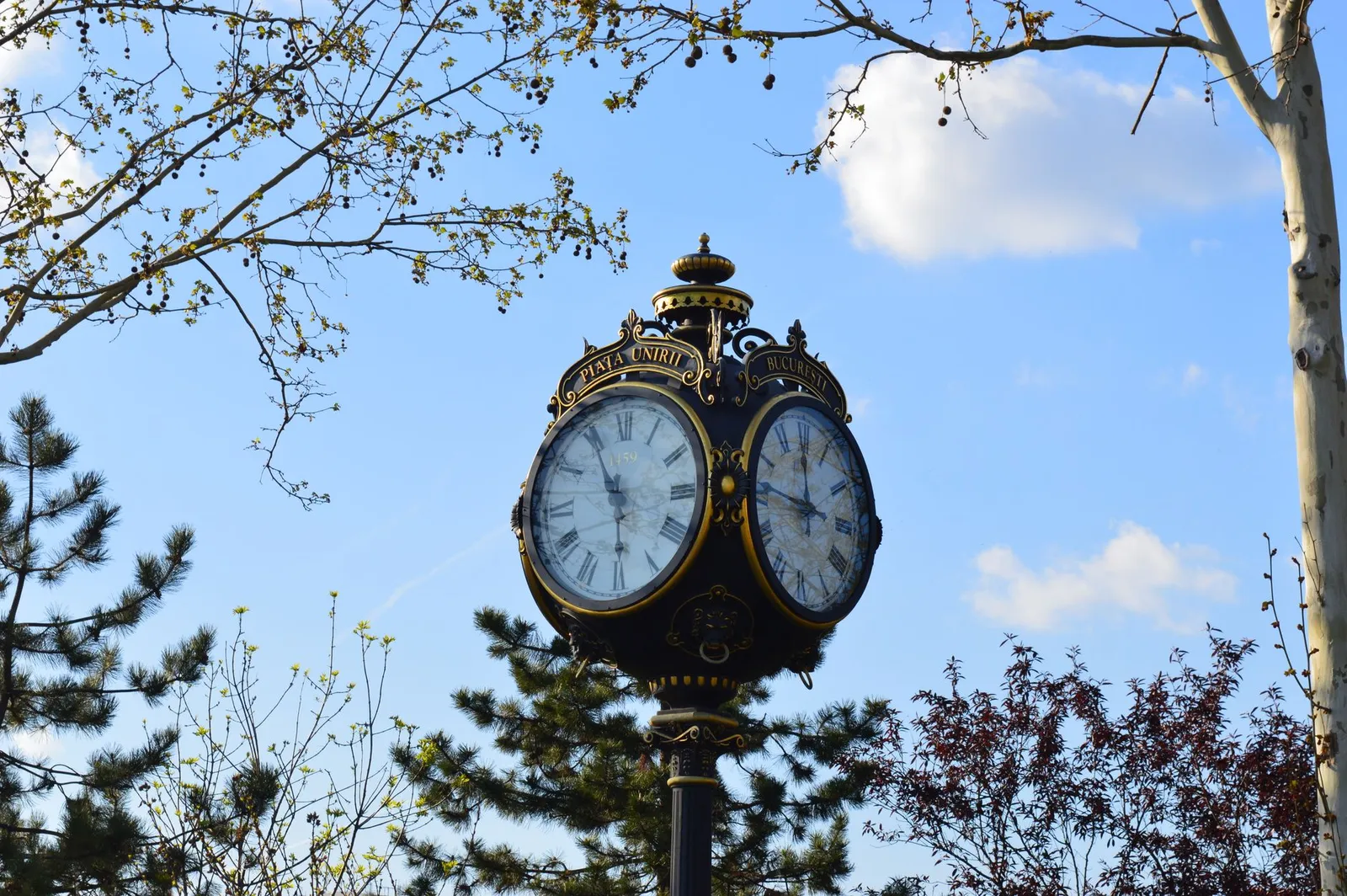 A close-up of a historic clock tower in Piata Unirii, Bucharest, Romania.