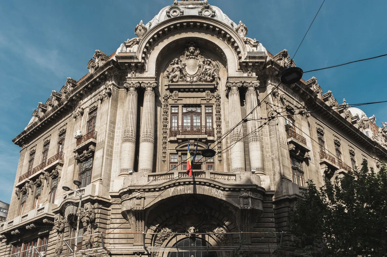 Captivating architecture of a historic building in Bucharest, showcasing classical details under a clear blue sky.