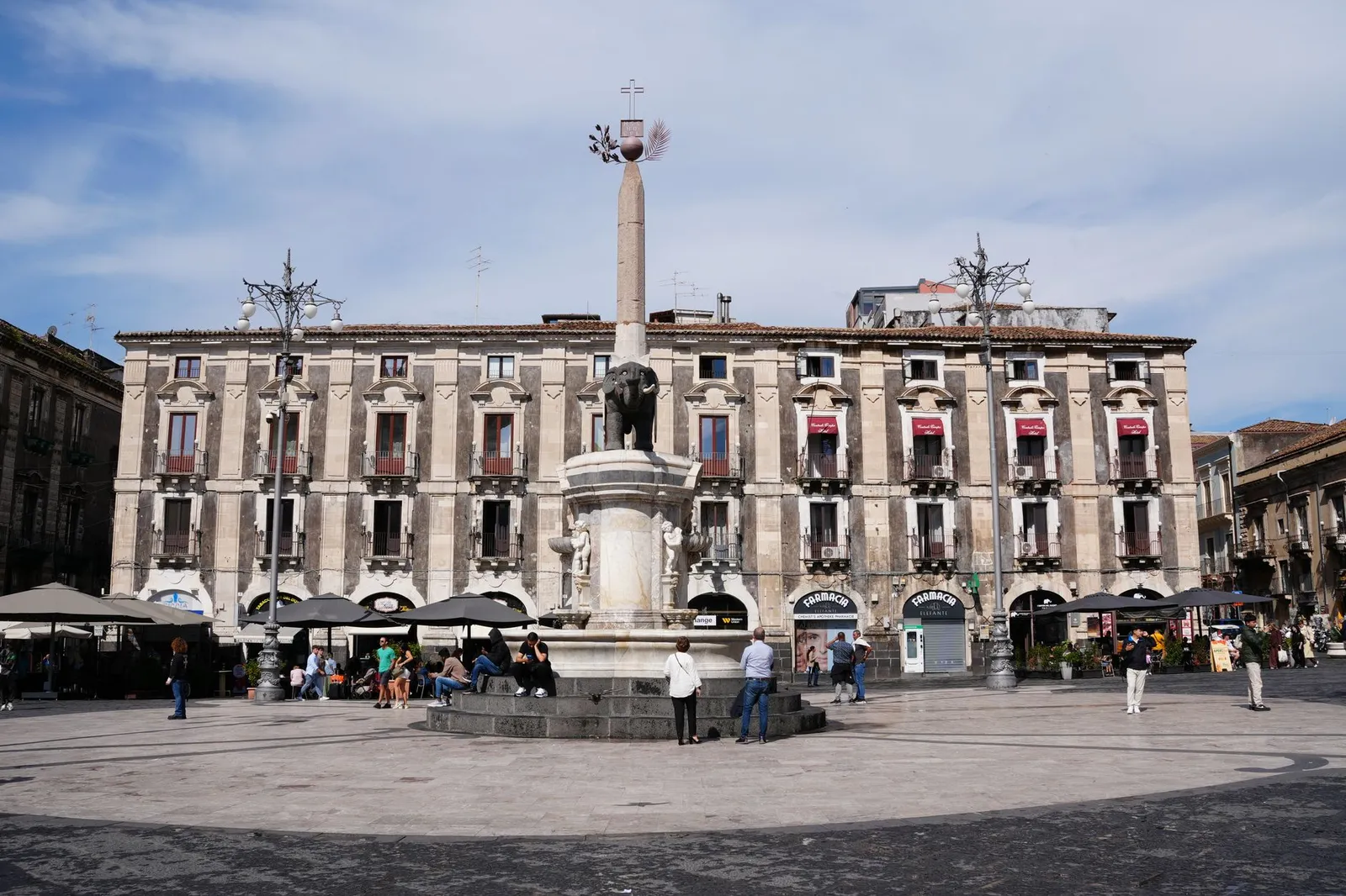 The iconic Elephant Fountain in Piazza del Duomo, Catania, Sicily showcasing vibrant urban life.