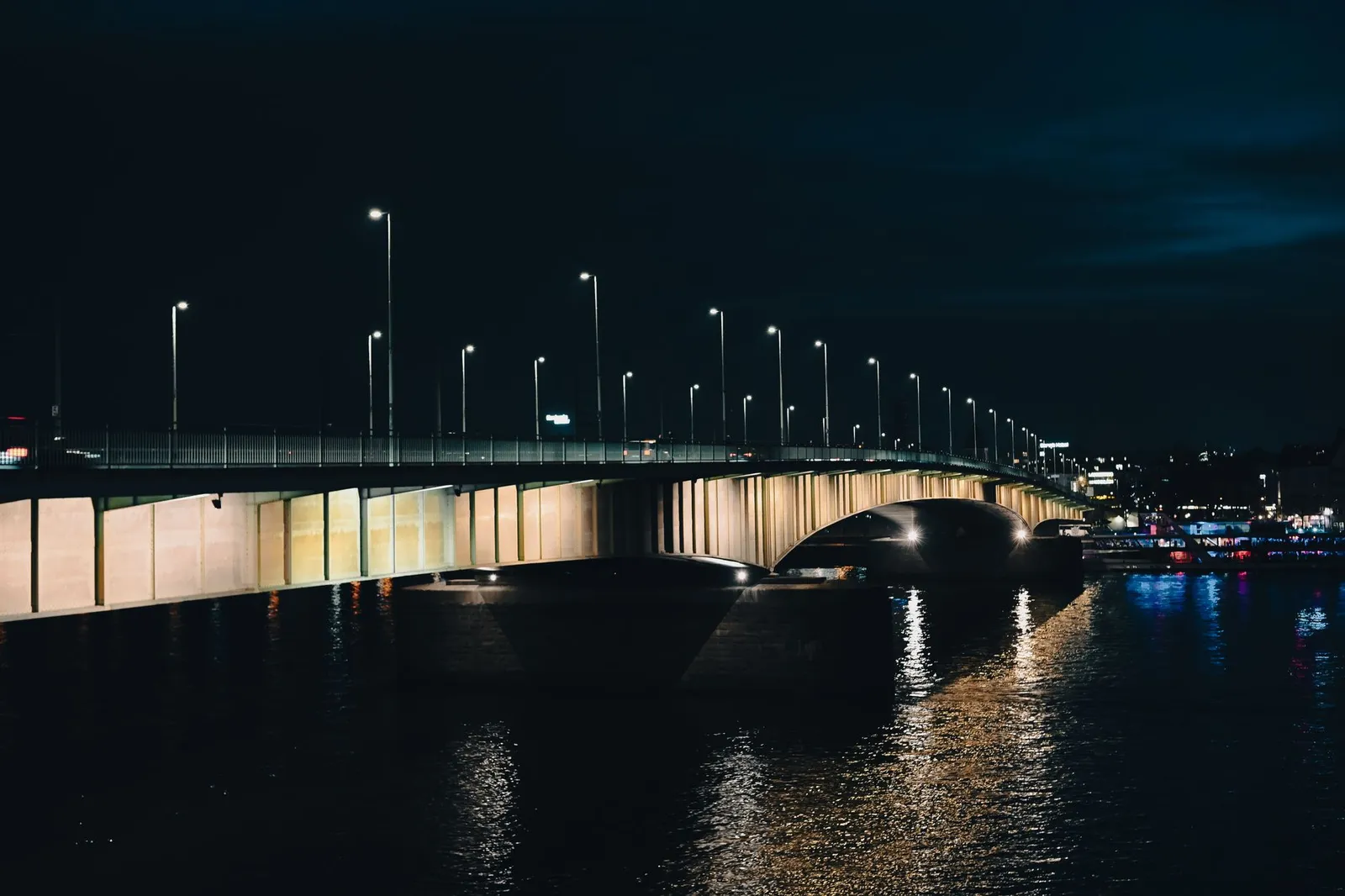Stunning night view of an illuminated bridge over the Rhine River in Cologne, Germany.
