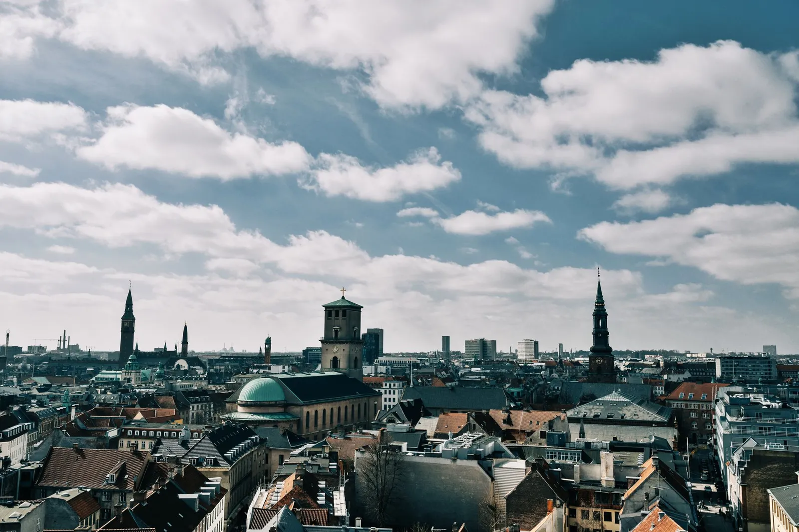 Stunning aerial view of Copenhagen's cityscape under a vibrant blue sky, showcasing historic spires and architecture.
