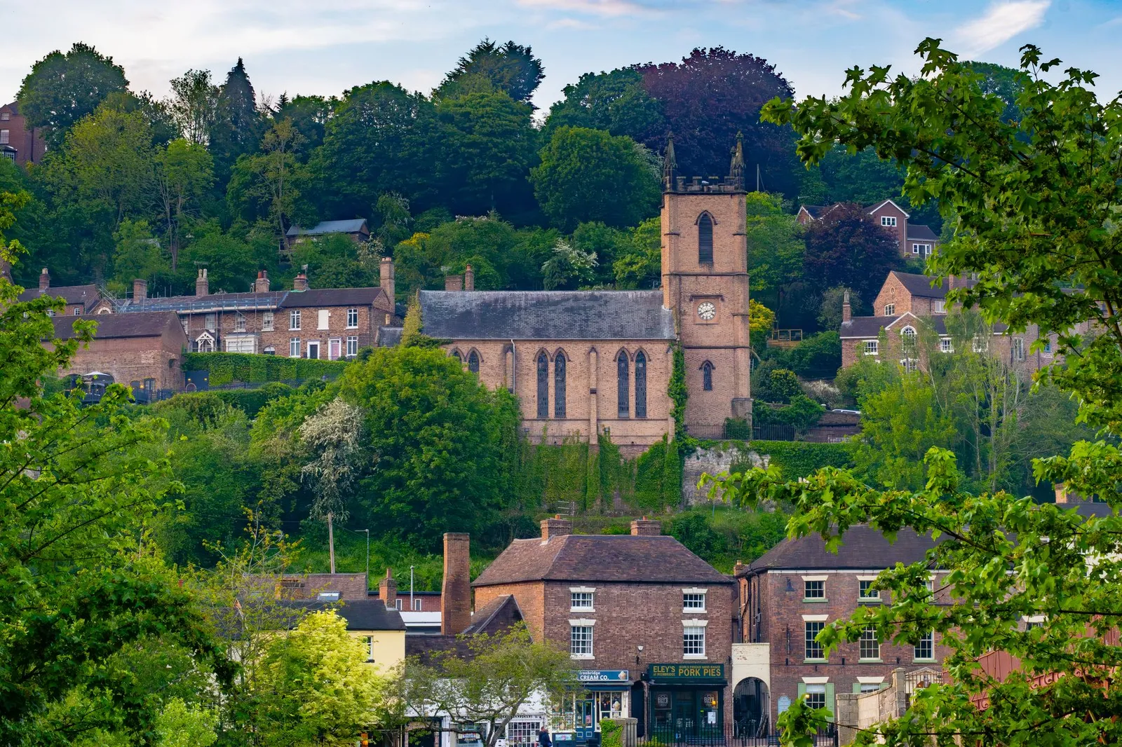 A picturesque view of St. Luke's Church and surrounding greenery in Ironbridge, England.