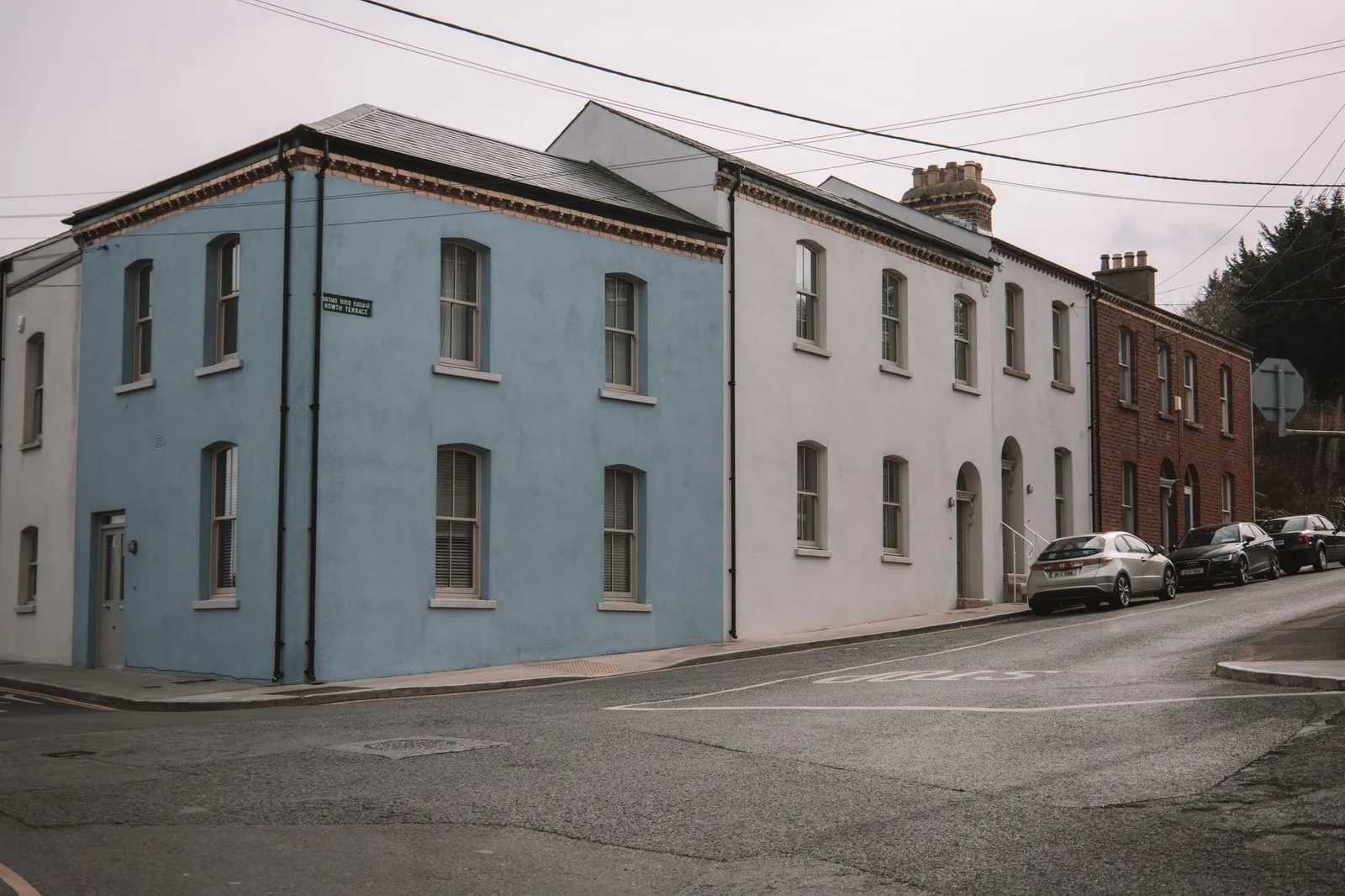 Street view in Dublin featuring vibrant blue, white, and brick houses capturing urban charm.