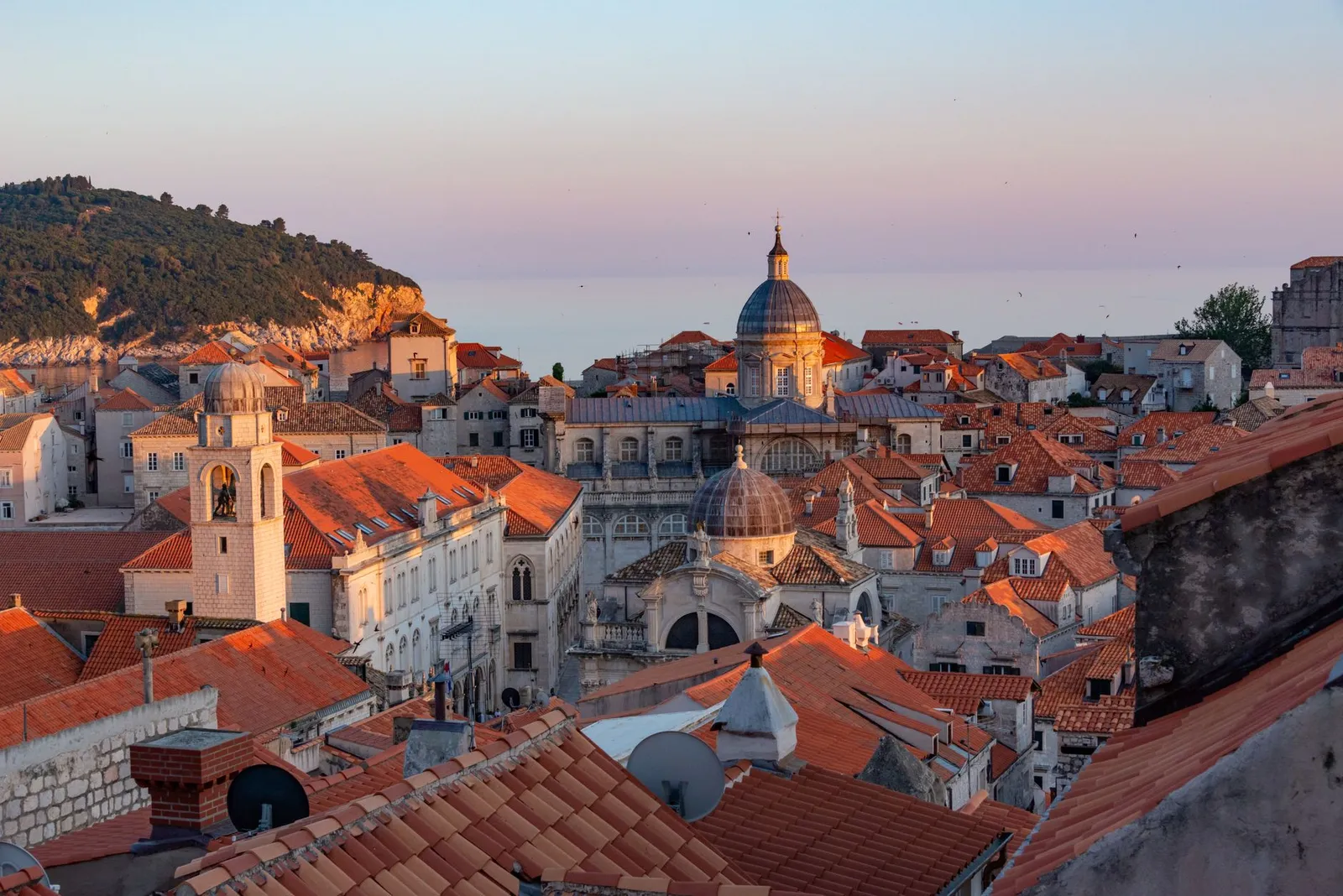Captivating sunset over Dubrovnik's Old Town, showcasing iconic terracotta rooftops and historic architecture.