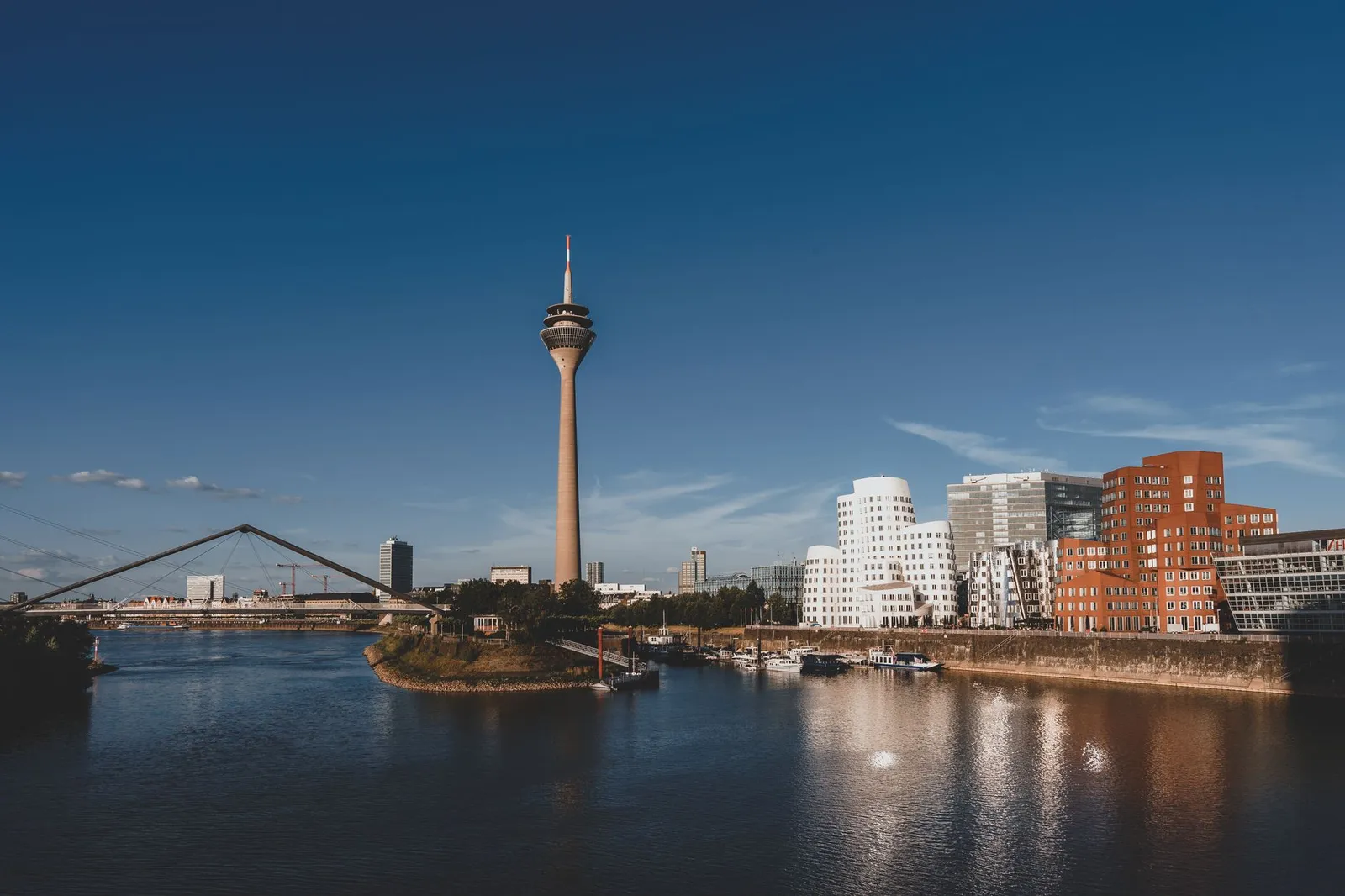 Stunning view of Düsseldorf with Rheinturm and modern architecture reflected in the Rhine River.