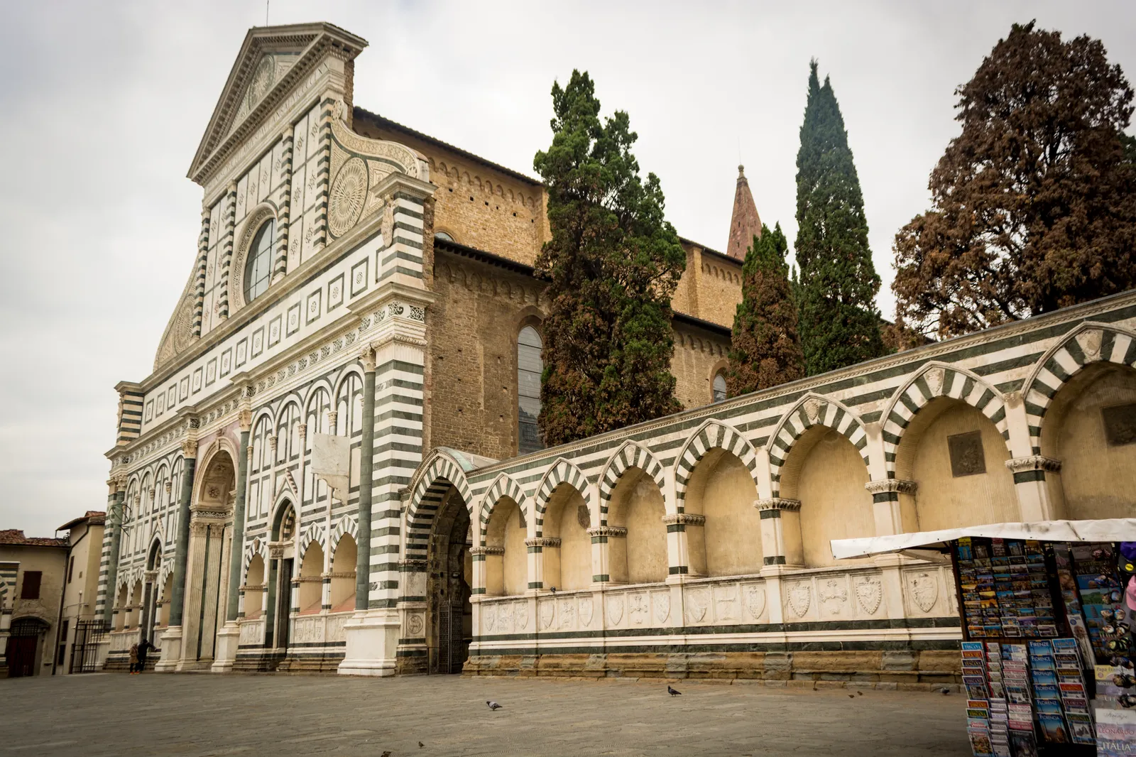 Low angle view of Santa Maria Novella's historic facade in Florence's gloomy weather.