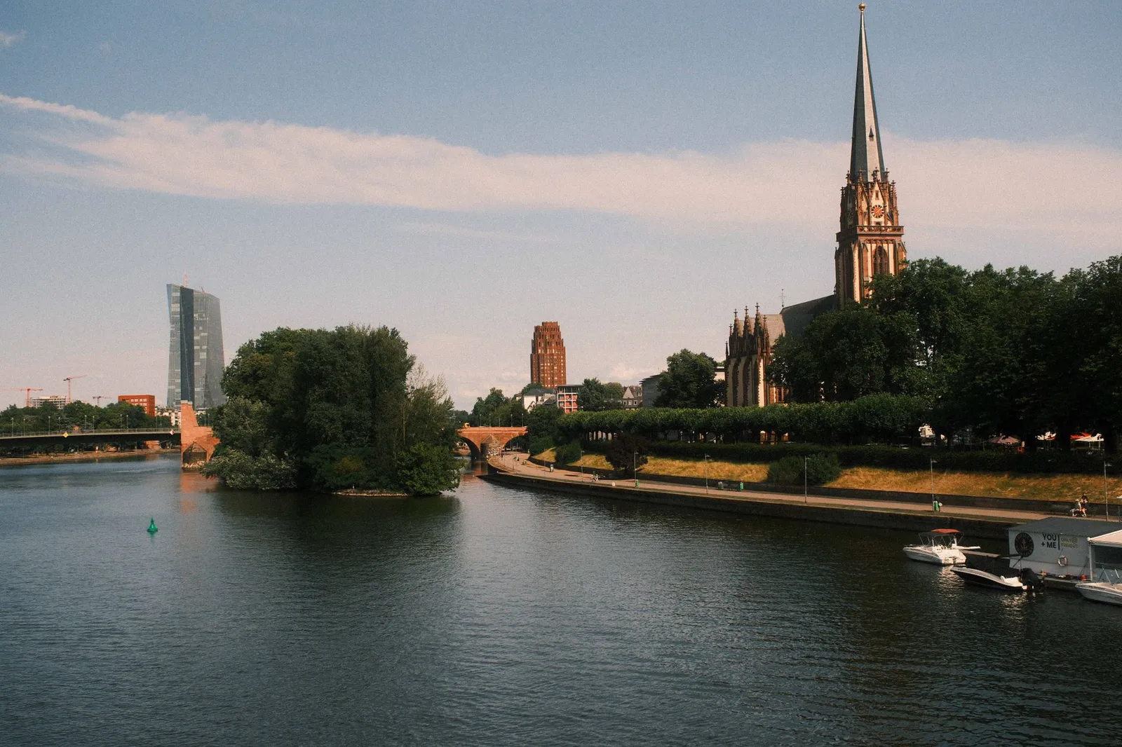 Capture of Frankfurt's iconic skyline featuring a cathedral by the River Main with moody lighting.
