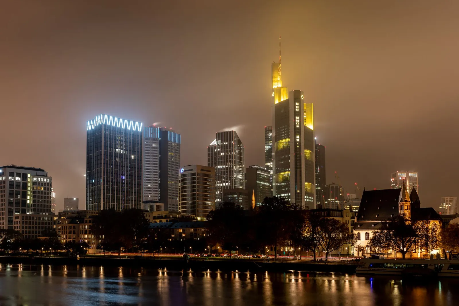 Beautiful night view of Frankfurt's illuminated skyline reflecting on the Main River.