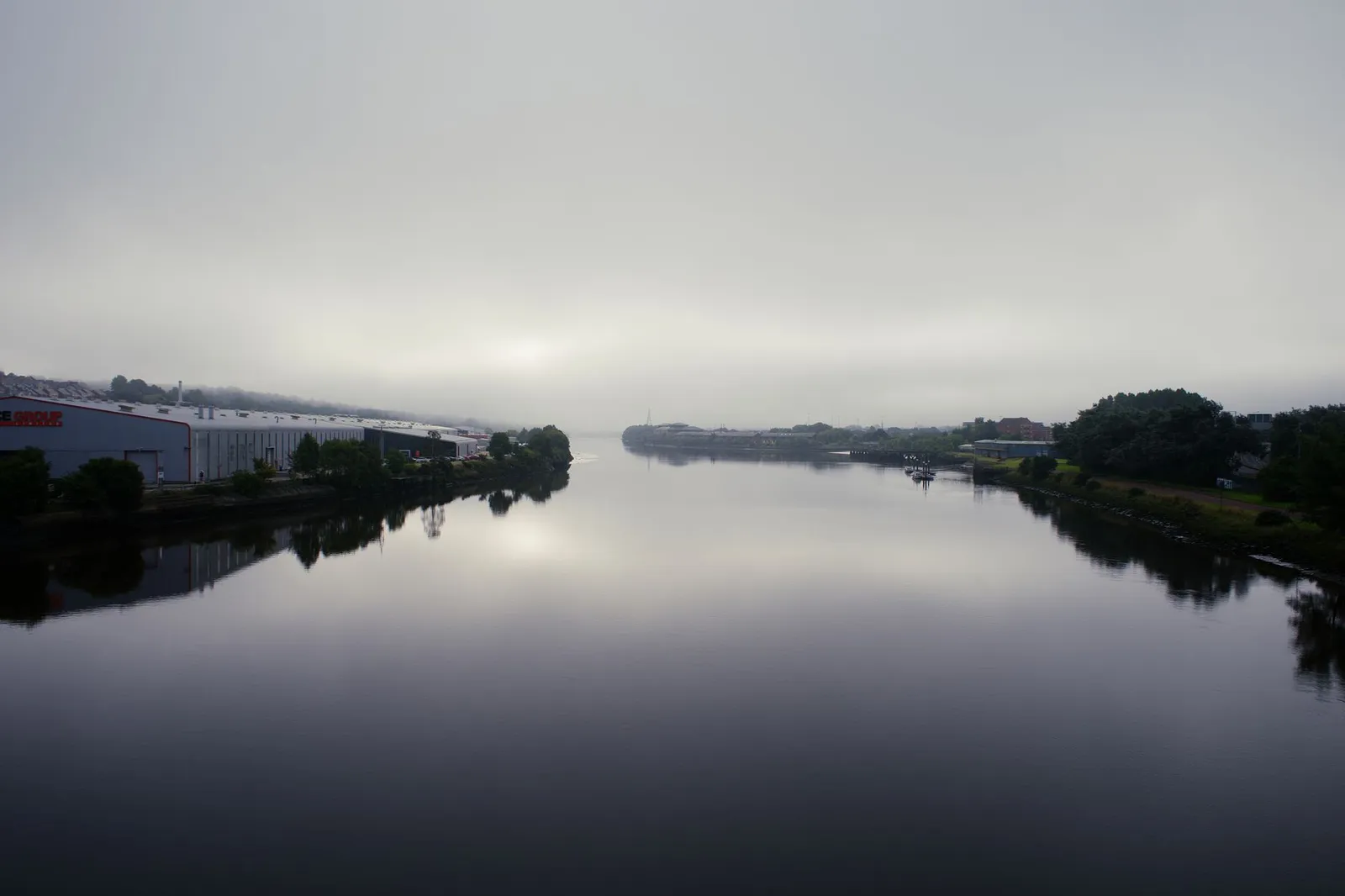 Serene foggy scene of the River Tyne in Newcastle upon Tyne, England, with overcast skies.