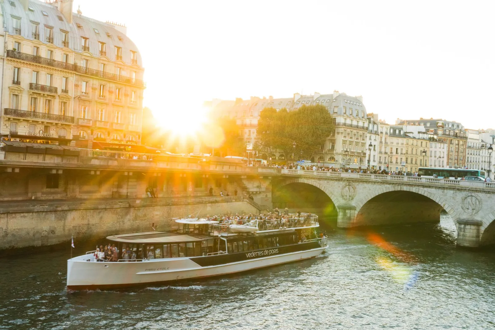 A scenic view of a river cruise boat on the Seine during sunset in Paris.
