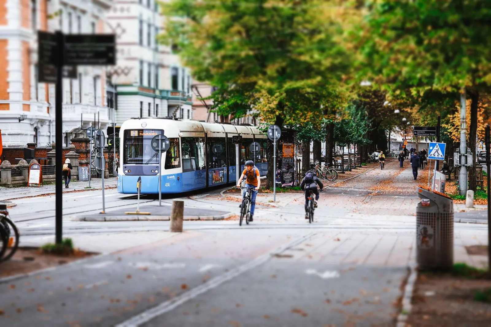Dynamic urban scene with cyclists and tram in Gothenburg, Sweden, showcasing city life.