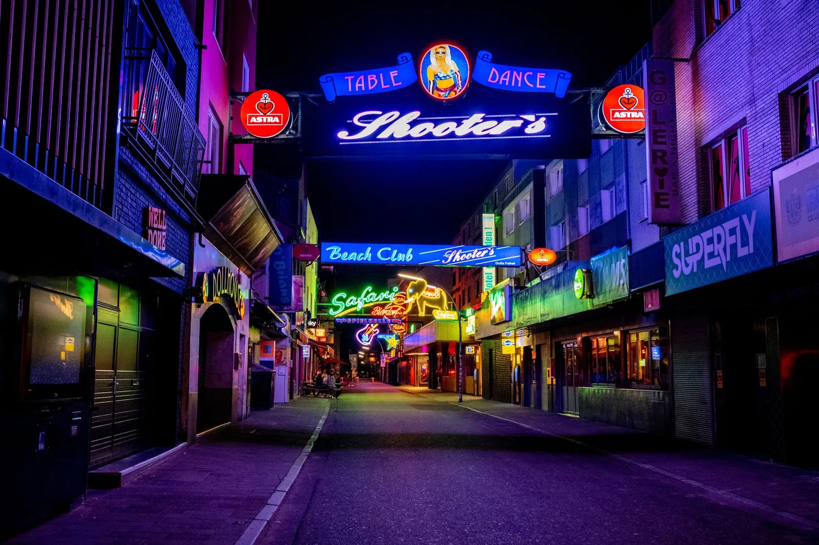 Explore the vibrant neon-lit streets of Hamburg's famous Reeperbahn district at night.