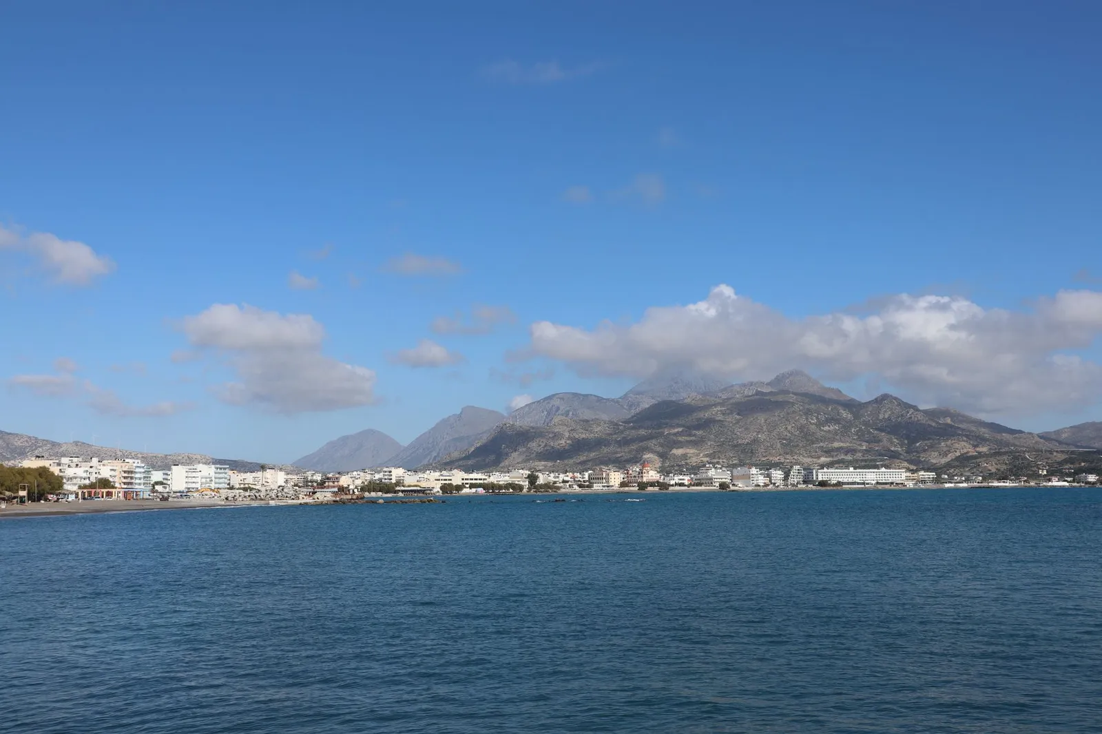 Breathtaking view of Ierapetra's coastline, with mountains under a clear blue sky.