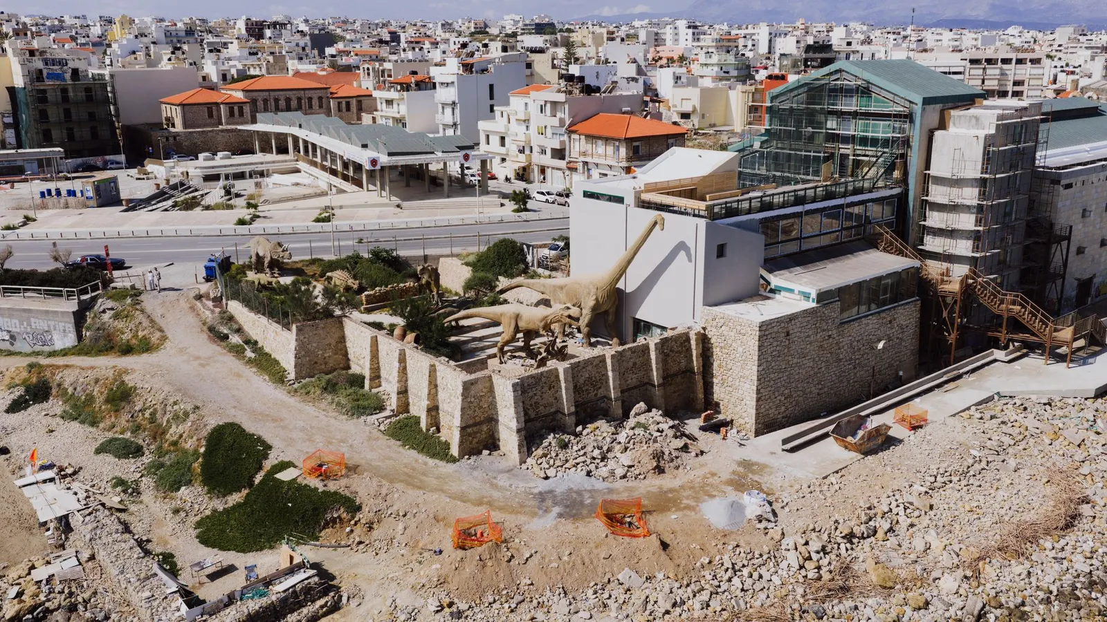 Aerial shot of Heraklion Natural History Museum showcasing dinosaur models and urban landscape.
