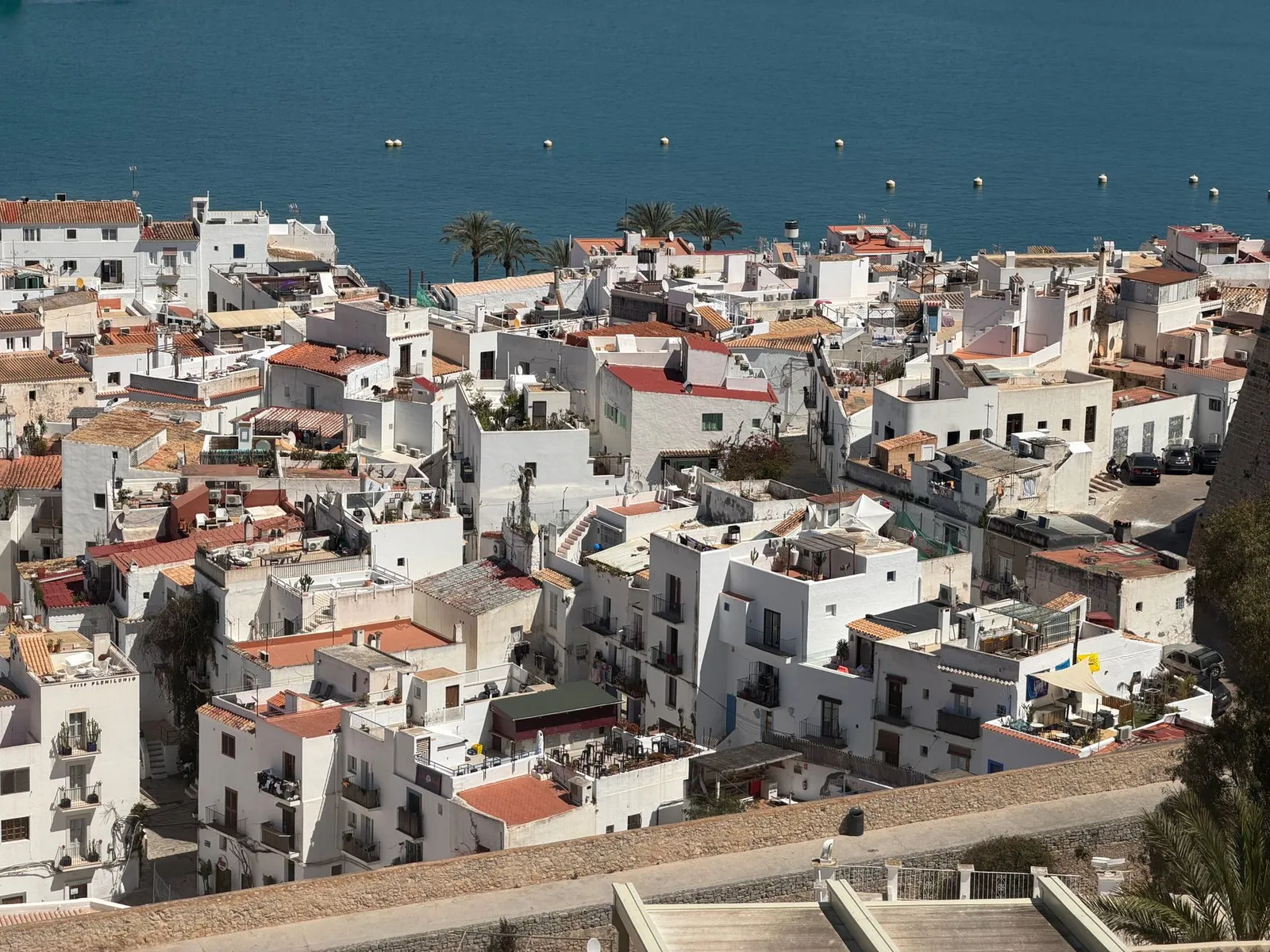 Aerial perspective of the picturesque whitewashed buildings in Eivissa, Ibiza with a stunning sea backdrop.