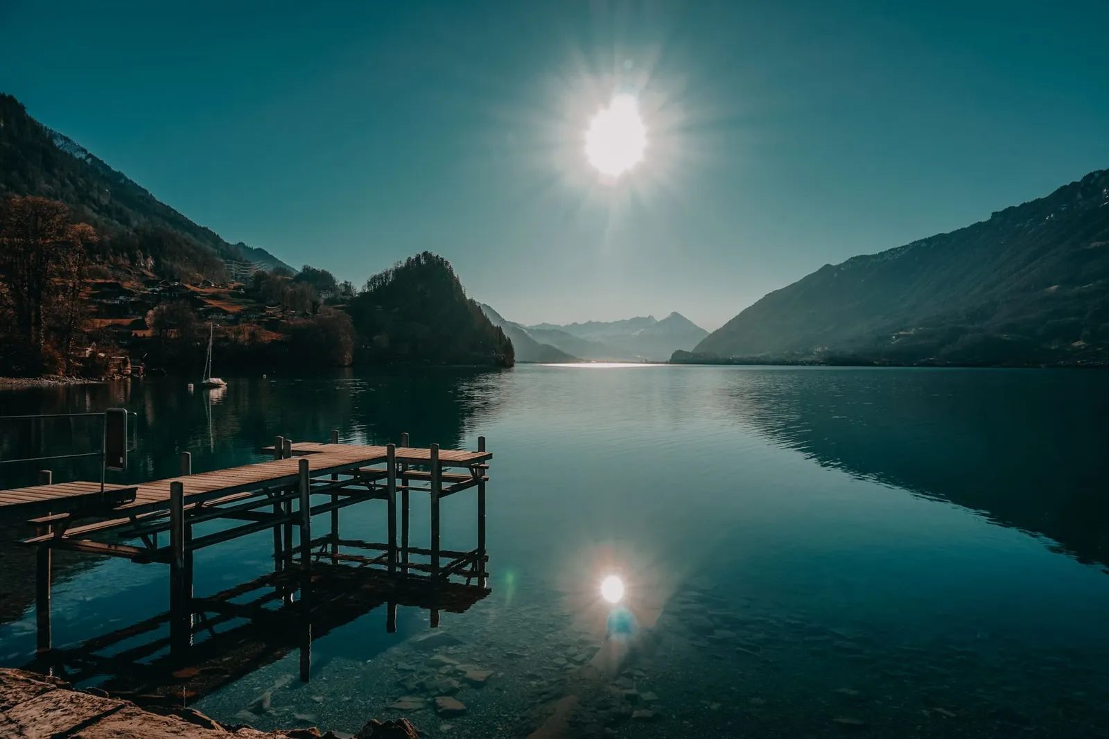 Scenic view of a tranquil lake and mountains at Interlaken, captured under bright daylight reflecting the serene natural beauty.