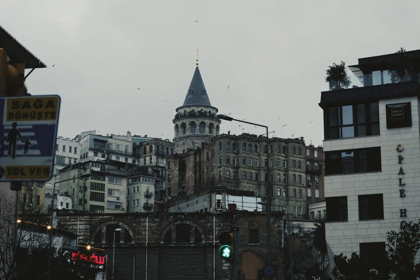 View of Galata Tower surrounded by historic buildings in Istanbul, Türkiye during the day.
