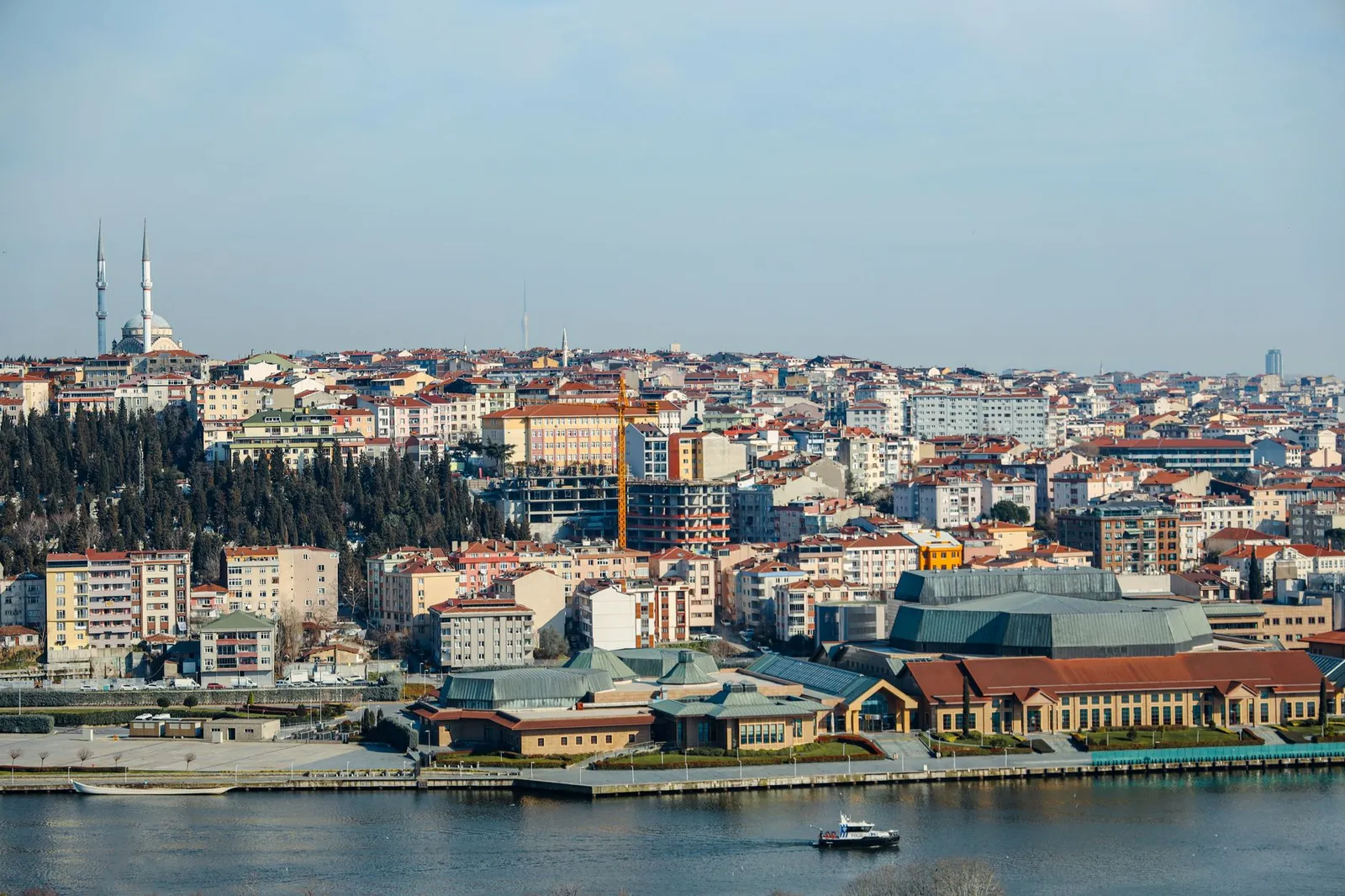 A scenic aerial view of Istanbul's skyline along the Bosphorus, capturing urban sprawl and a prominent mosque.