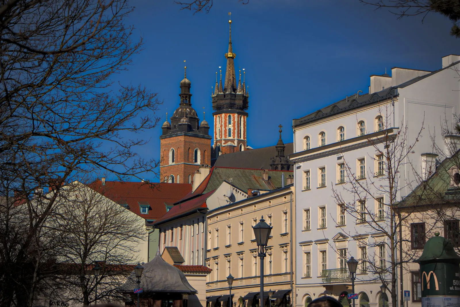 Vibrant view of St. Mary's Basilica and charming Kraków architecture under a clear blue sky.
