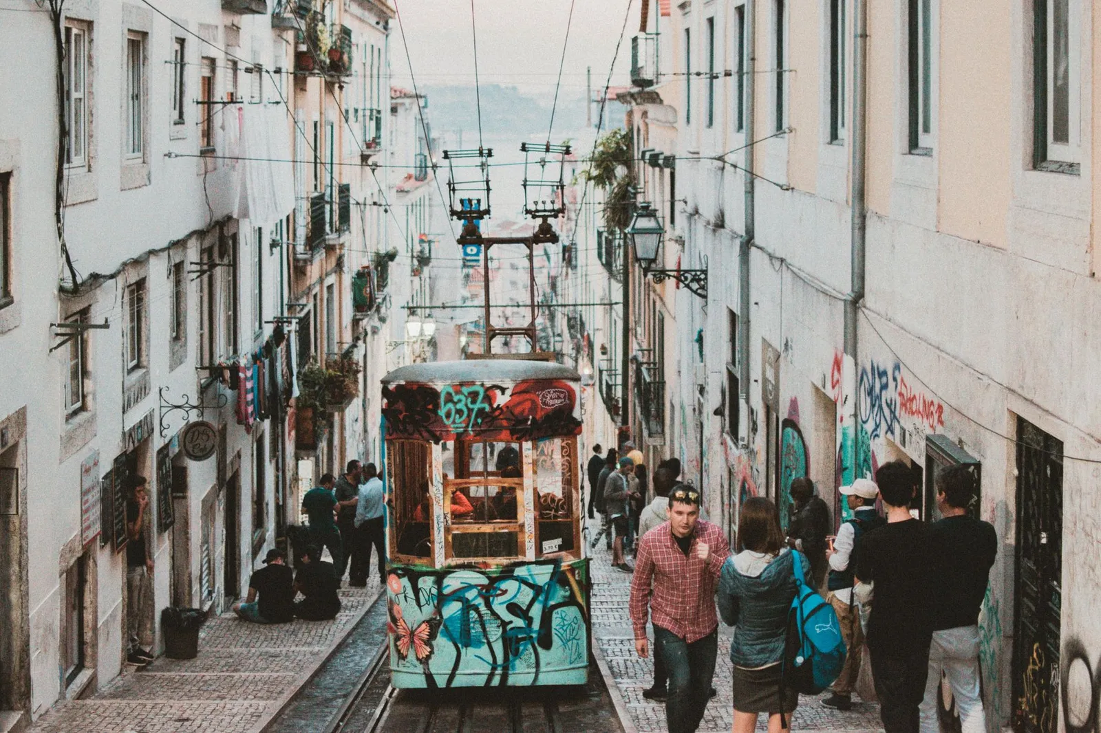 A lively urban view in Lisbon featuring a colorful tram and busy street.