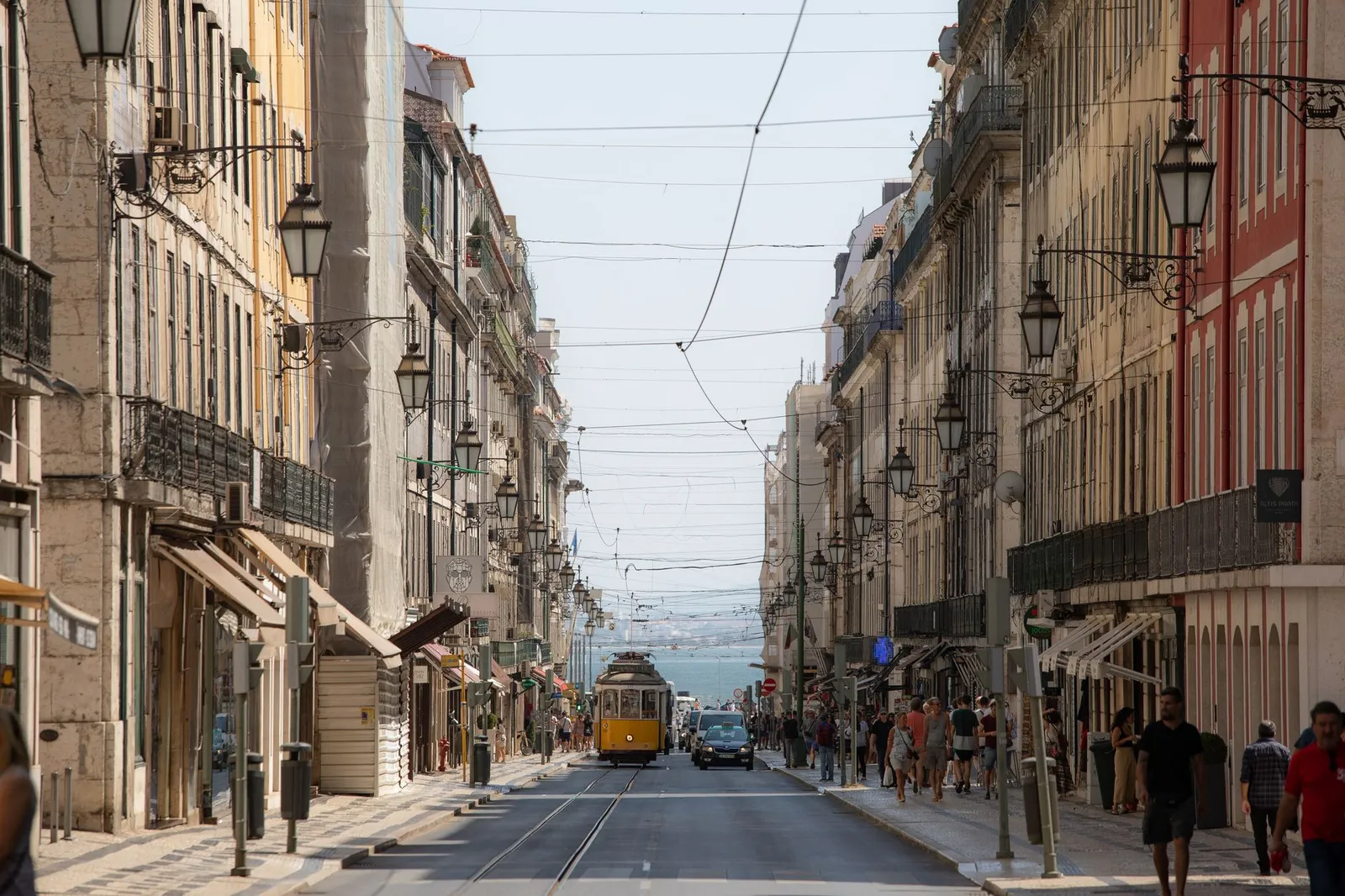 A bustling day in Lisbon featuring historic architecture and the classic yellow tram.