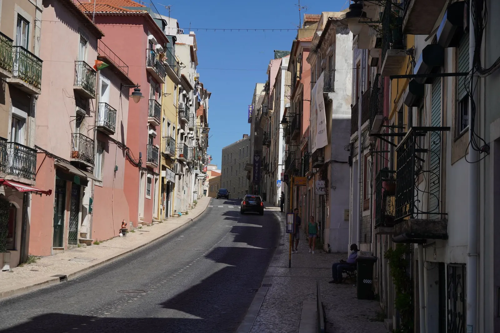 Charming Lisbon street scene with colorful buildings and a clear blue sky.