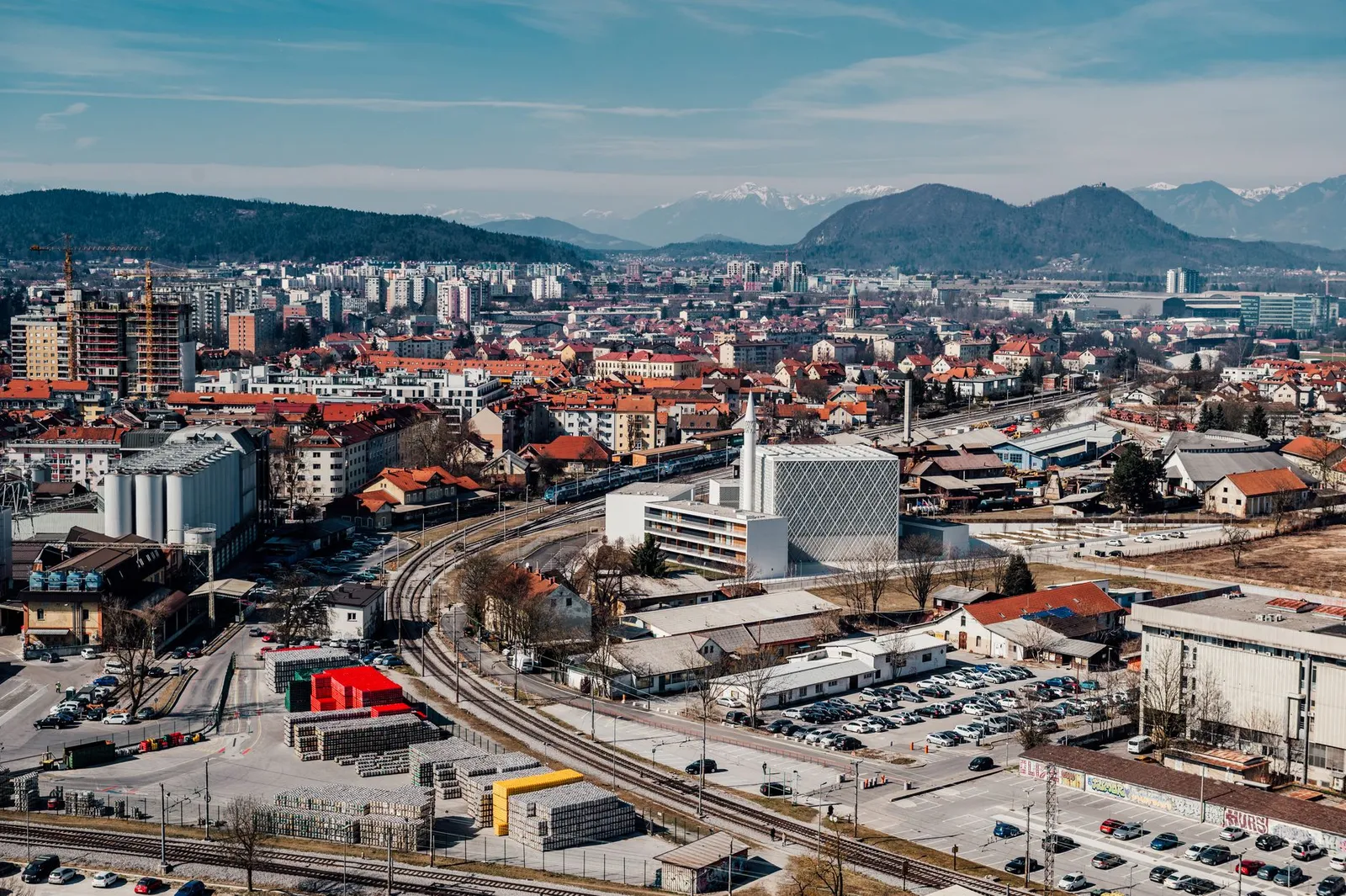 Explore the vibrant cityscape of Ljubljana, Slovenia with this stunning aerial view featuring urban architecture and scenic mountains.