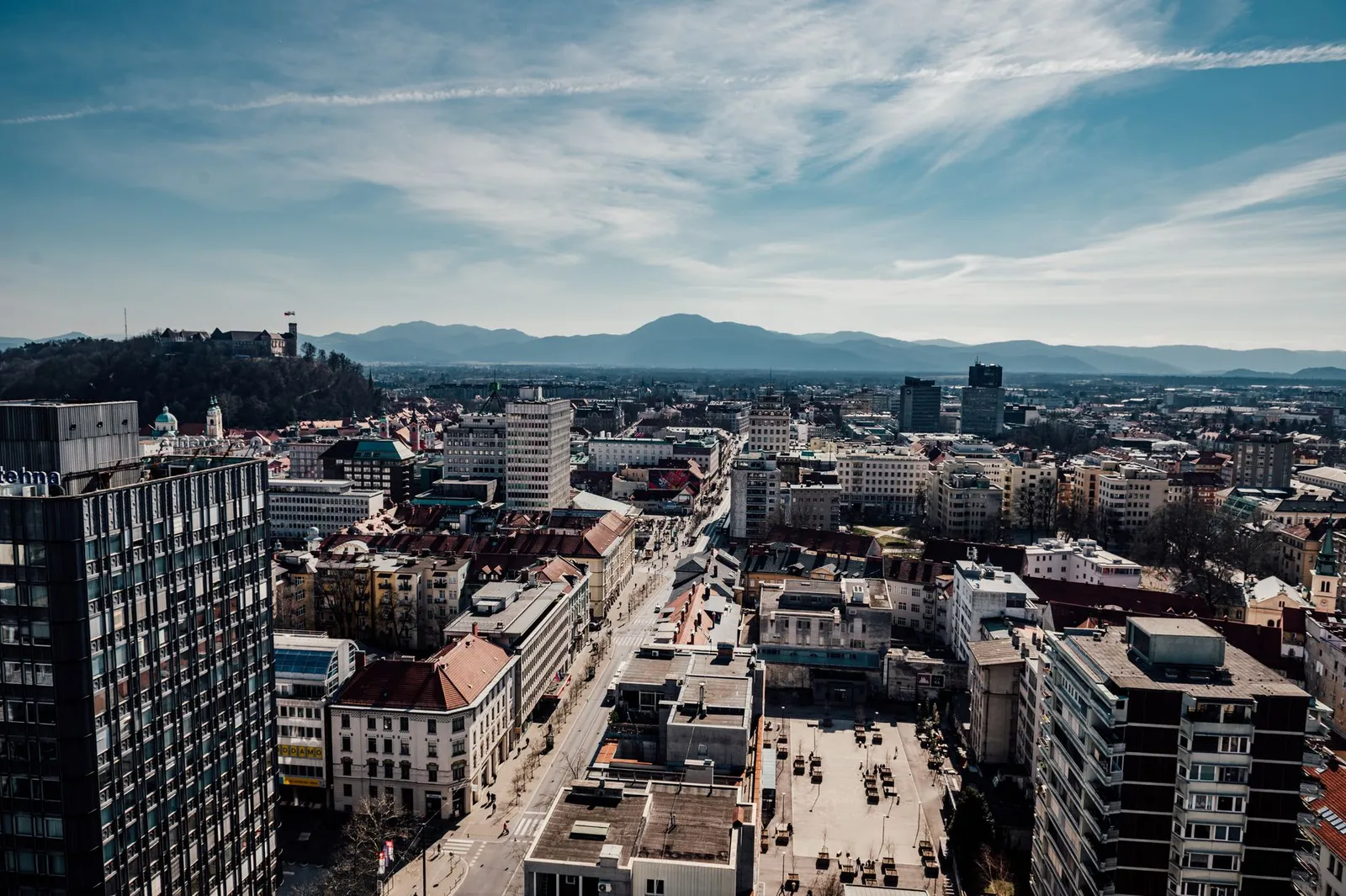 A stunning aerial view of Ljubljana, Slovenia featuring the city's buildings, castle, and surrounding mountains.