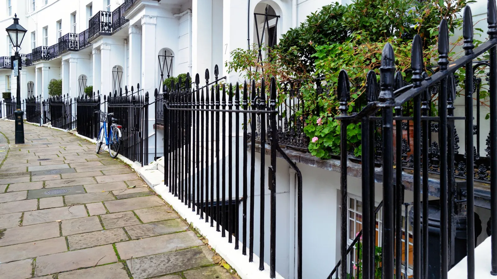 Stunning Georgian townhouses with classic ironwork in Kensington, London. Captured outdoors during the day.