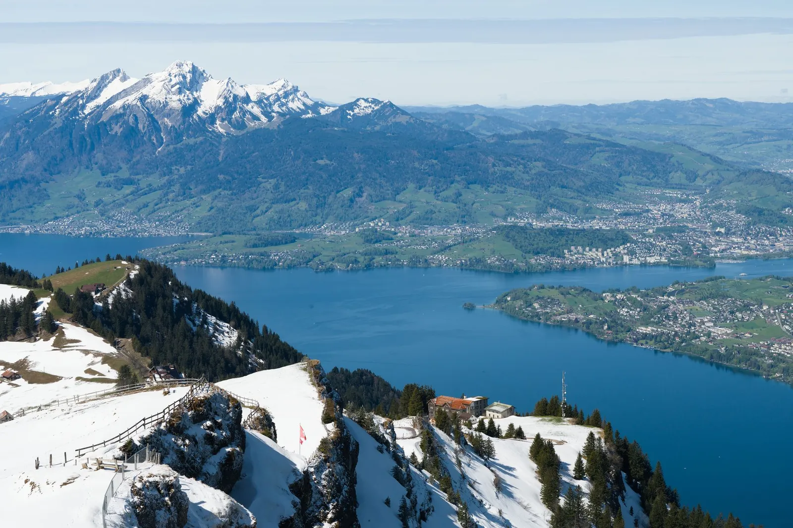 Breathtaking aerial view of snowy Mount Rigi overlooking Lake Lucerne and Swiss Alps scenery.