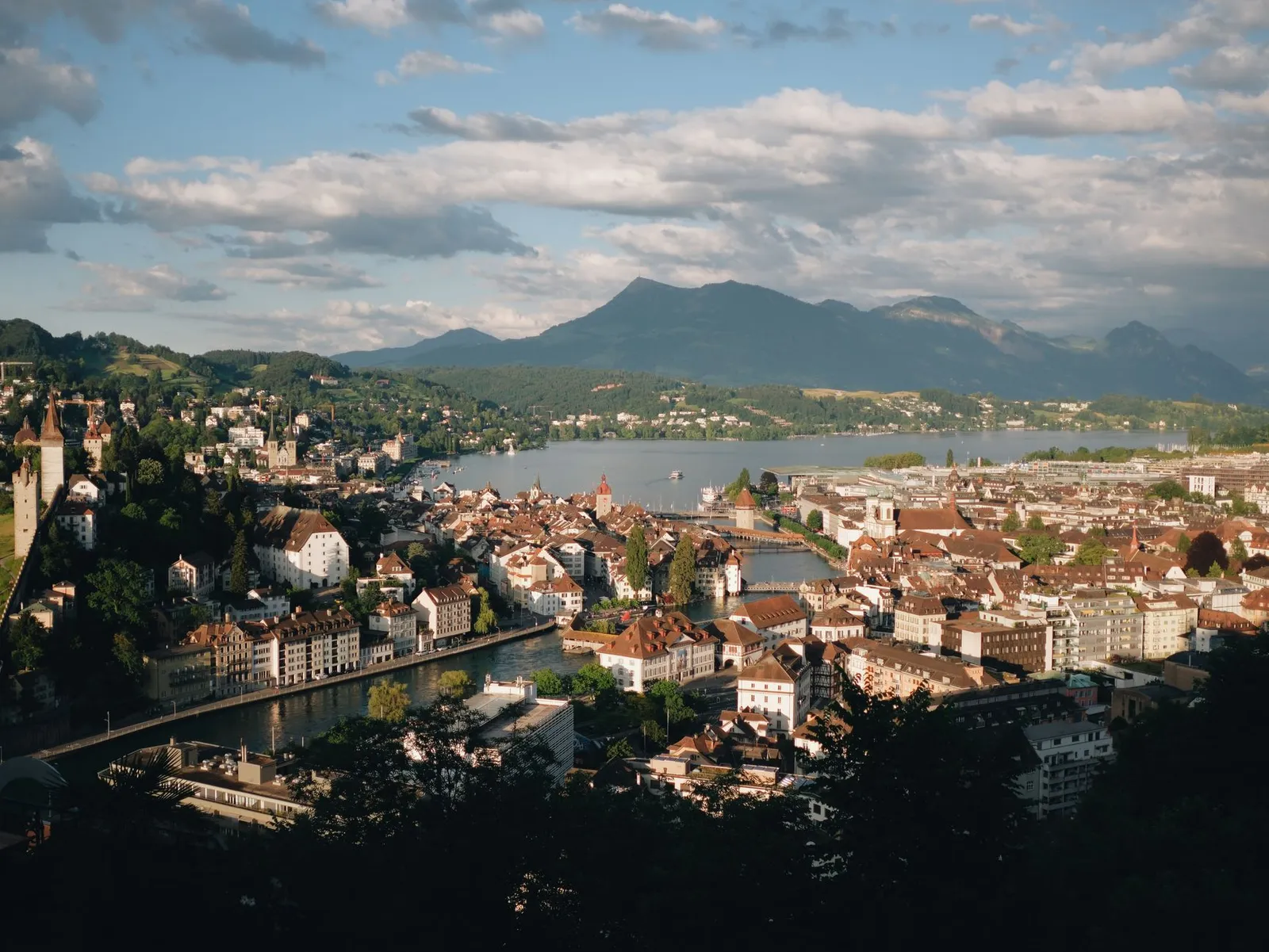 A picturesque aerial view of Lucerne, Switzerland featuring the cityscape, lake, and surrounding mountains.