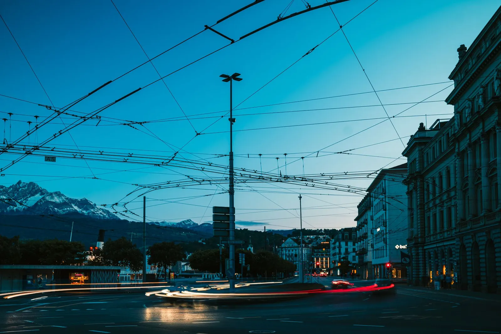 Dramatic evening view of Lucerne, Switzerland showing urban motion blur and mountain backdrop.