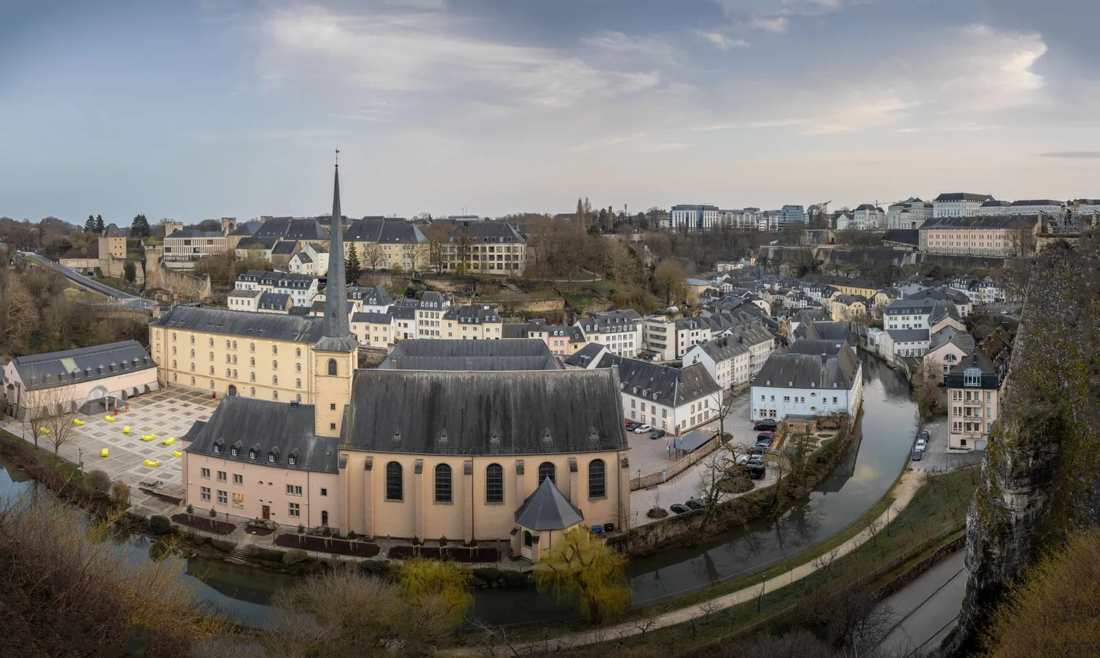 Aerial panoramic view of Luxembourg City featuring the Abbey of Neumünster and winding river.