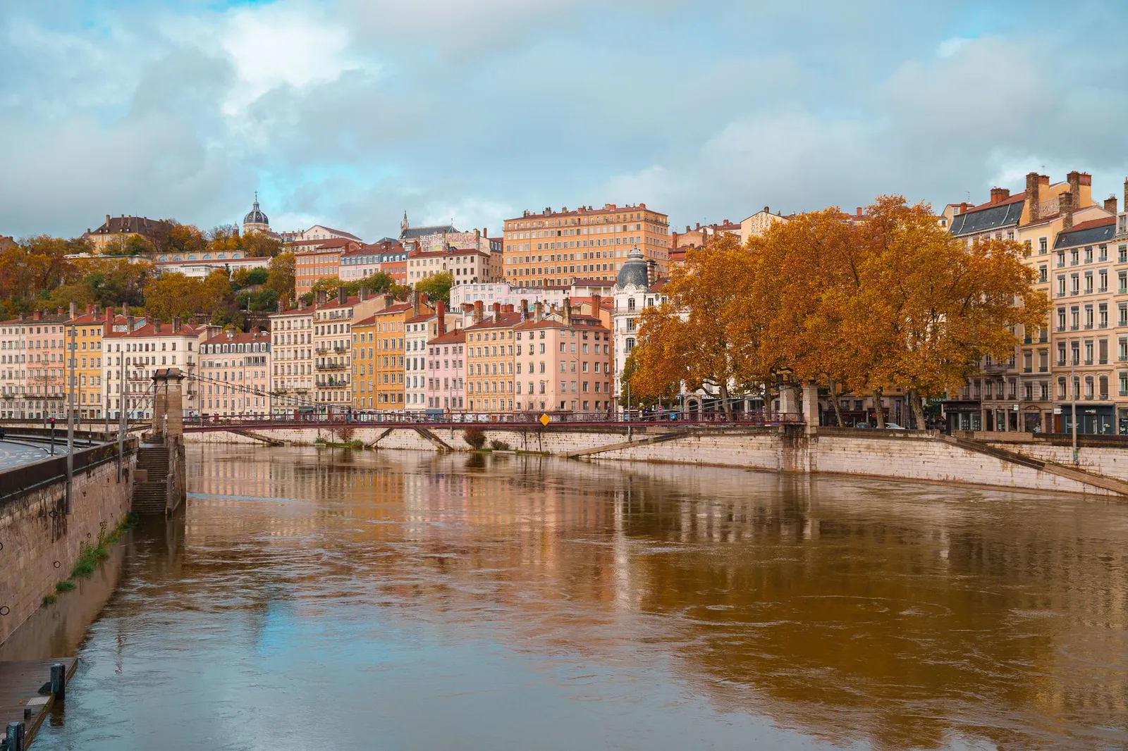 Beautiful autumn scene of the Saône River and Lyon's architecture in Auvergne-Rhône-Alpes, France.