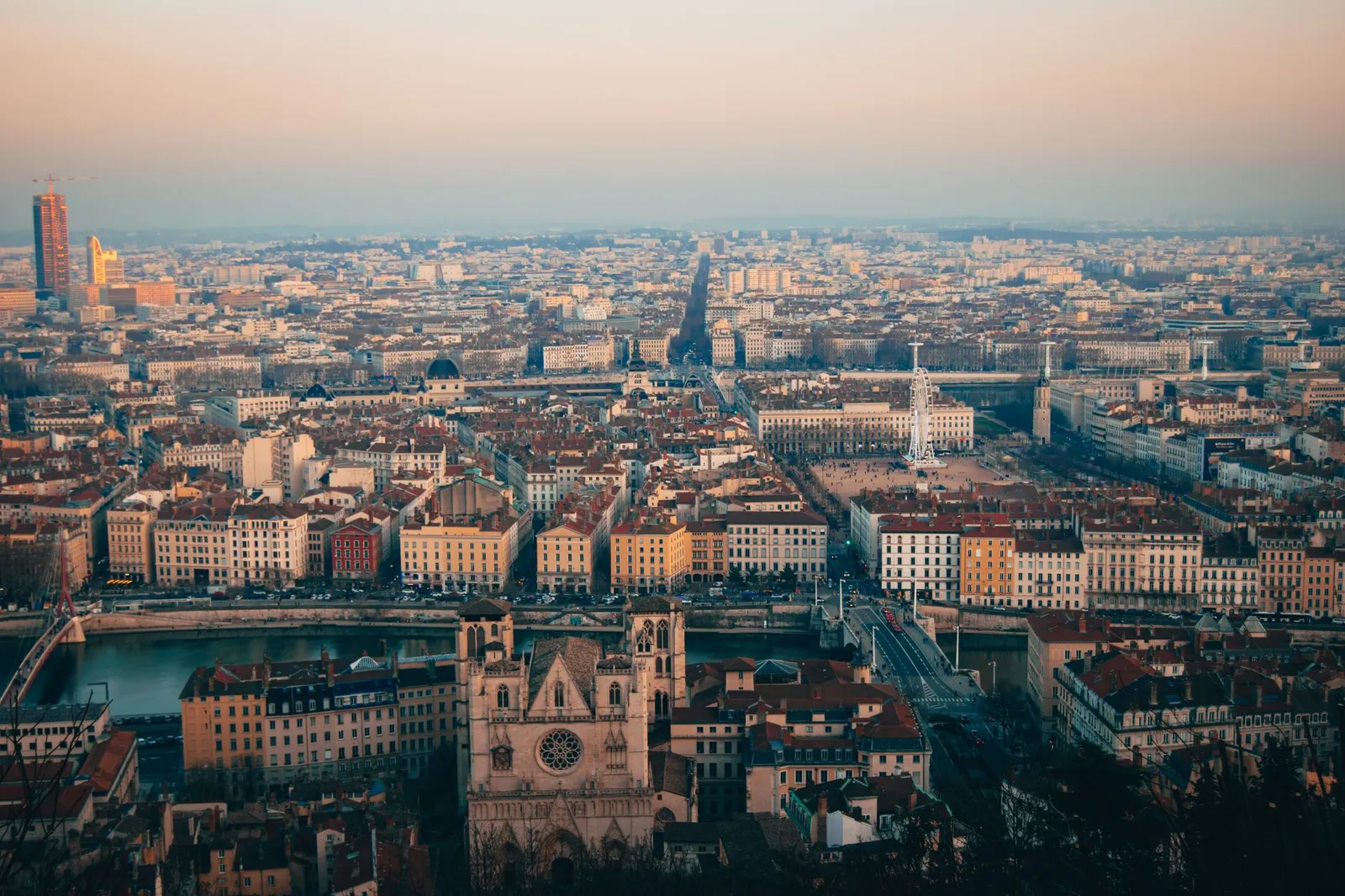 Stunning aerial view of Lyon cityscape during sunset, showcasing historic architecture and vibrant city life.