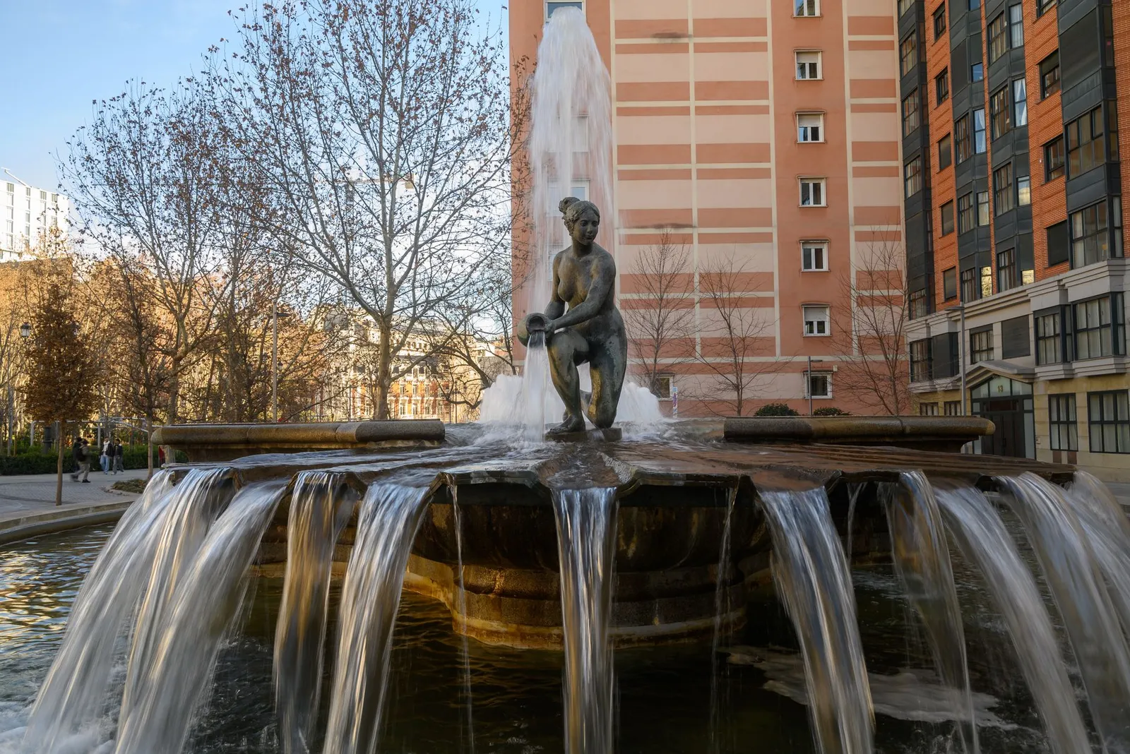 A beautiful fountain with a statue in a Madrid urban setting during fall.