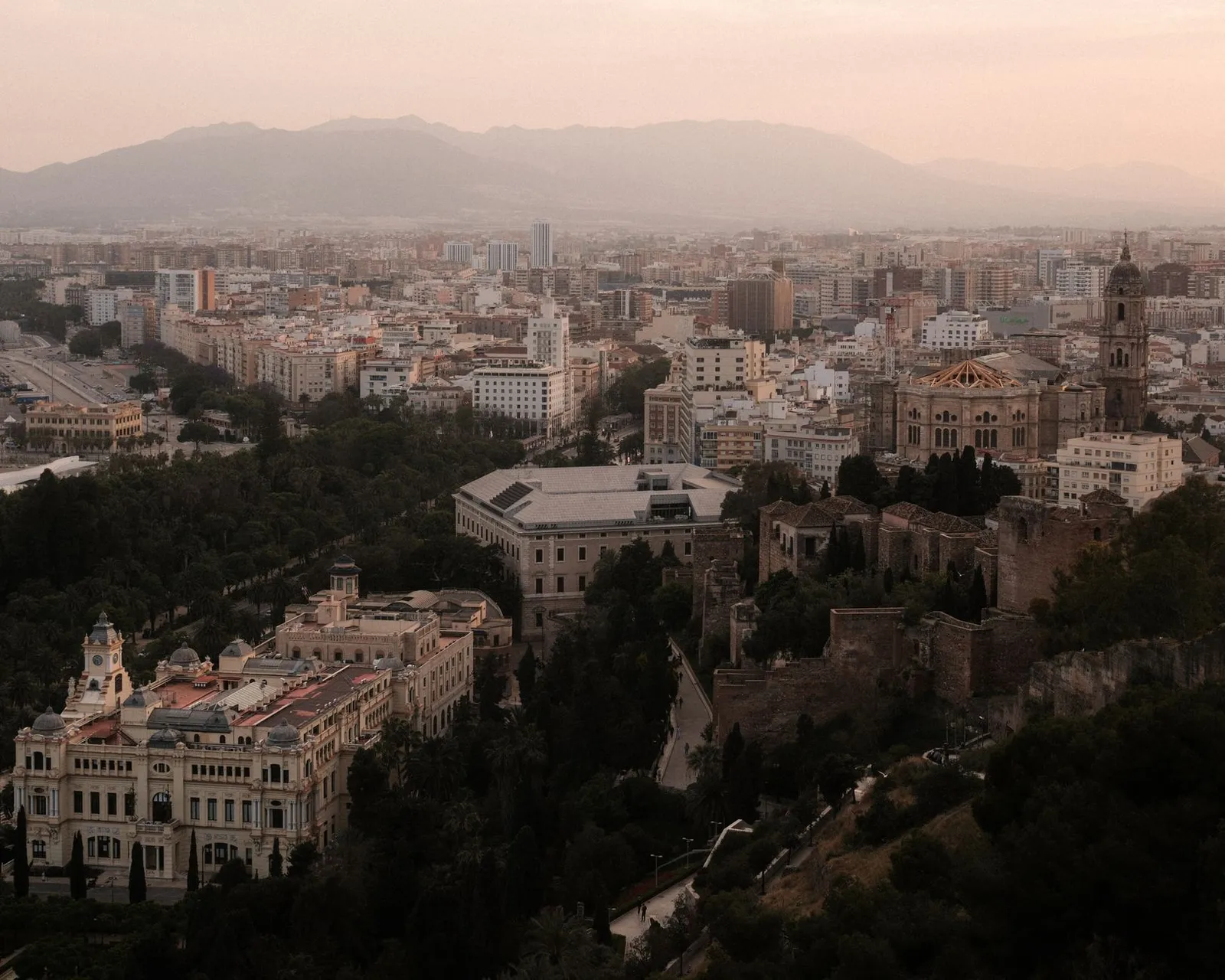 Stunning aerial shot of Málaga, Spain, showcasing landmarks at sunset.